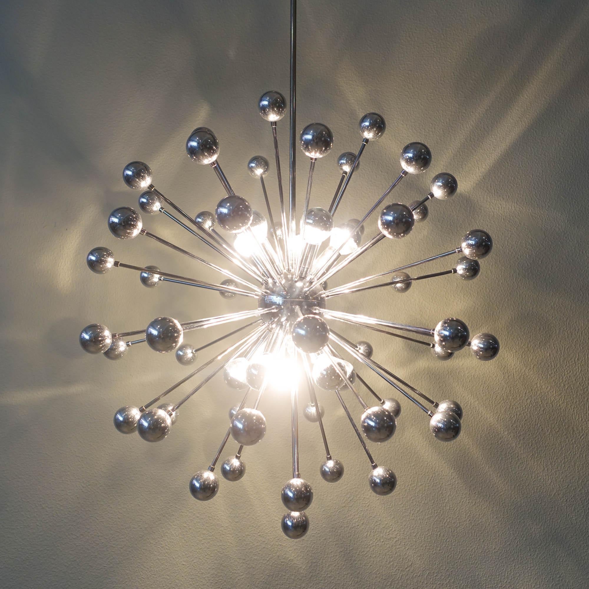 This ceiling lamp was designed and produced in Italy during the 1970's. It is a large chromed Sputnik chandelier with 10 light points. With a chrome globe in the middle were chromed metal rods are attached and point in every direction with chromed