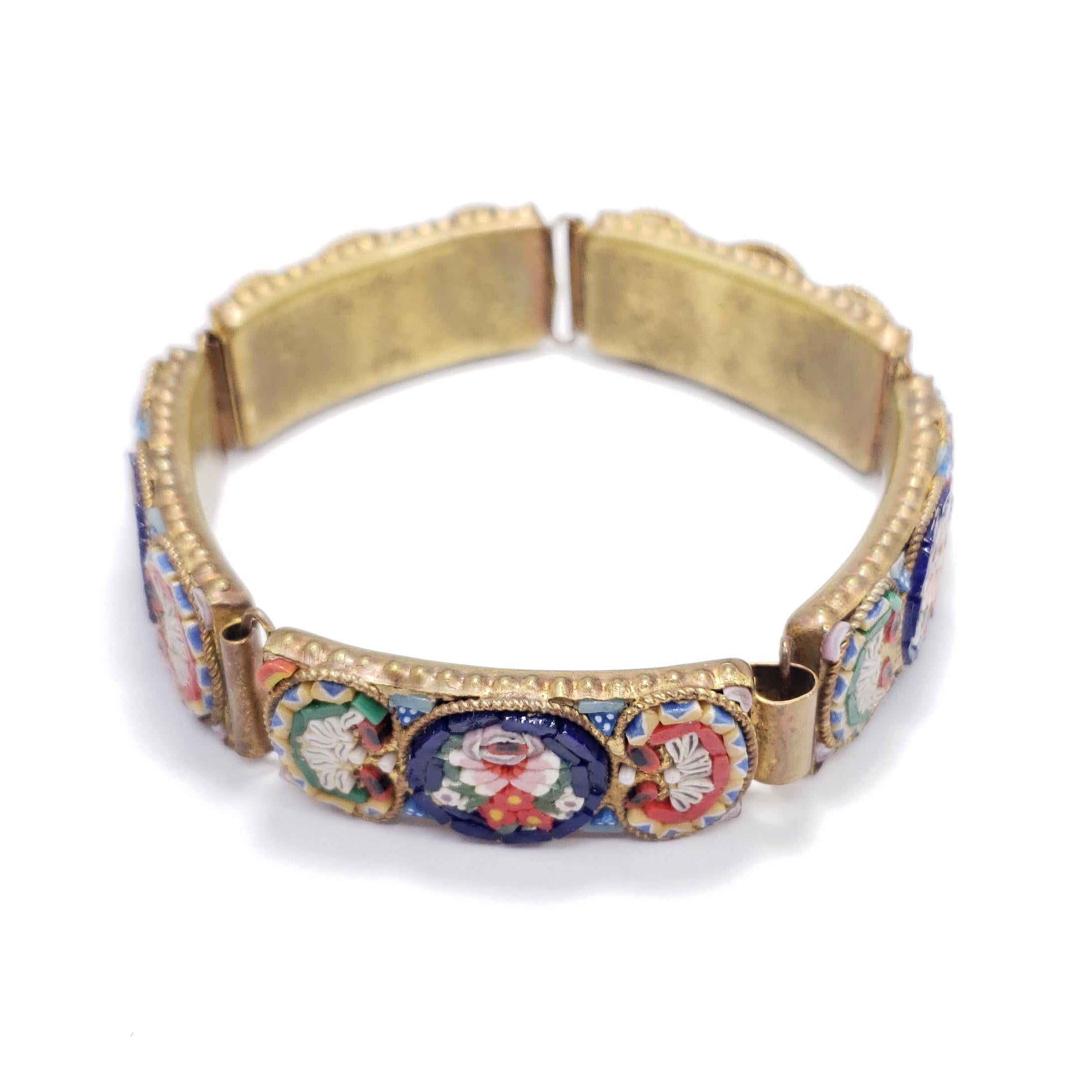 A stylish Italian cloisonne bracelet with blue, orange, white, and green floral motifs. Brass-tone setting. Circa early to mid 1900s.

Tags, Marks, Hallmarks: Italy