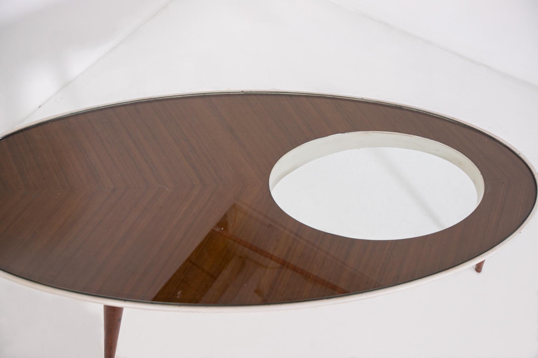 Beautiful vintage Italian coffee table inspired by Gio Ponti.
The Italian coffee table was made with glass and sturdy wood; the top is oval in shape and the feet are tapered.
The Italian coffee table inspired by Gio Ponti is ideal to place in