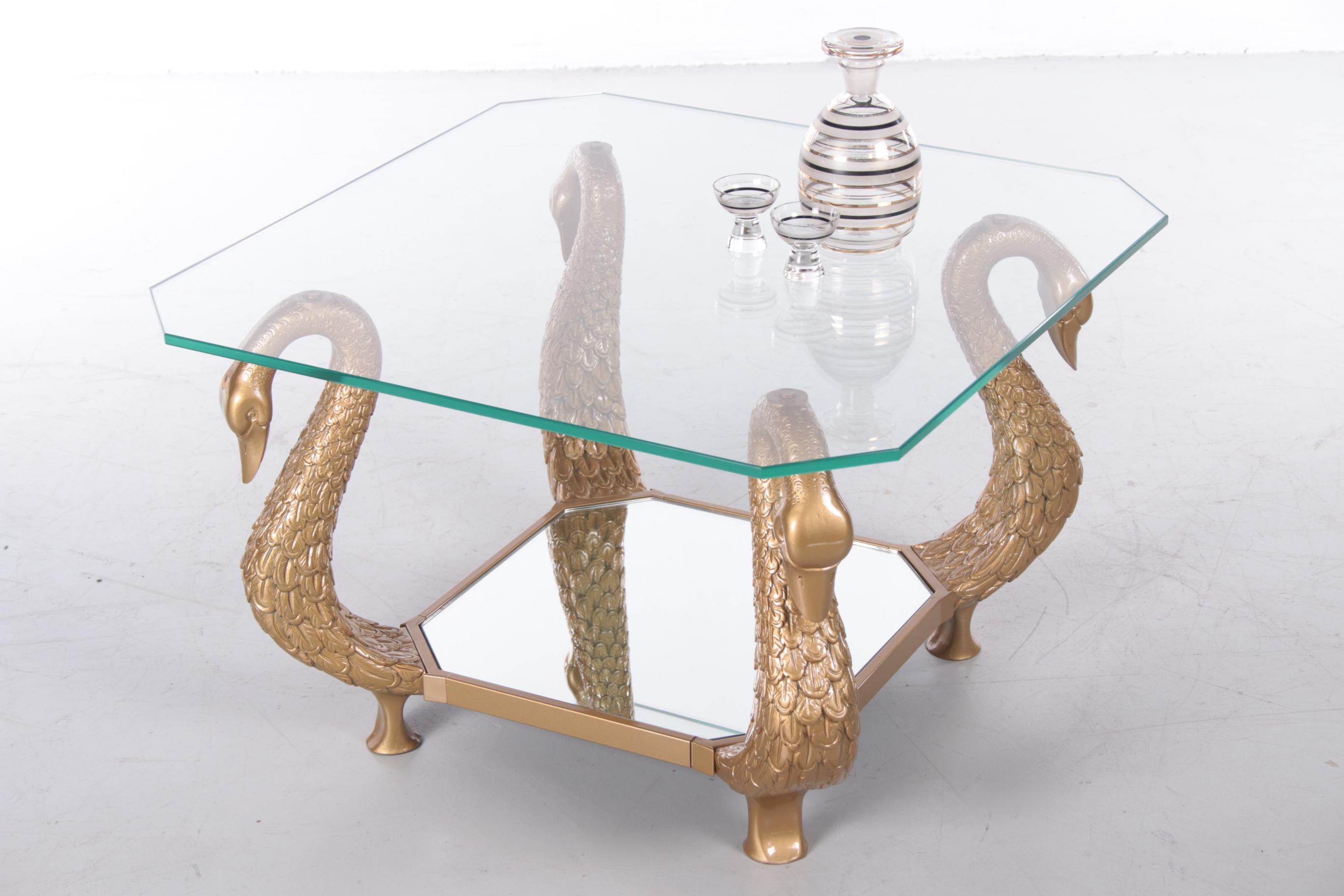 Stylish with allure'... That's how you can describe this beautiful Italian coffee table. Particularly beautiful detail are the golden swan busts that function as a base. The sleek glass plate with cut glass edge gives a stylish and minimalist