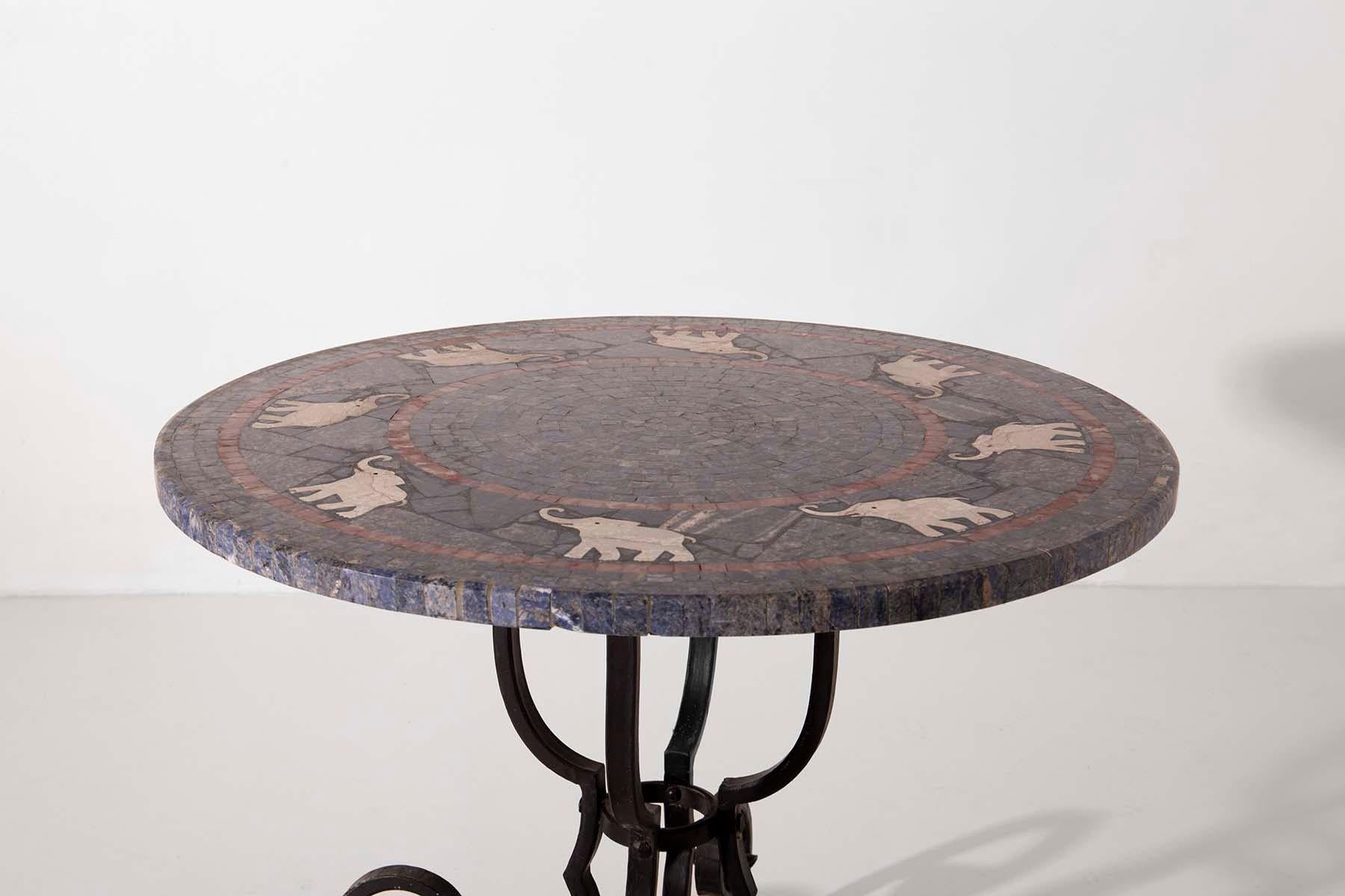 This extraordinary Italian-made coffee table from the early 1900s is a testament to the artistry and craftsmanship of a bygone era. The four wrought-iron legs culminate in elegant curls, adding a touch of grace to the entire table.

What sets this