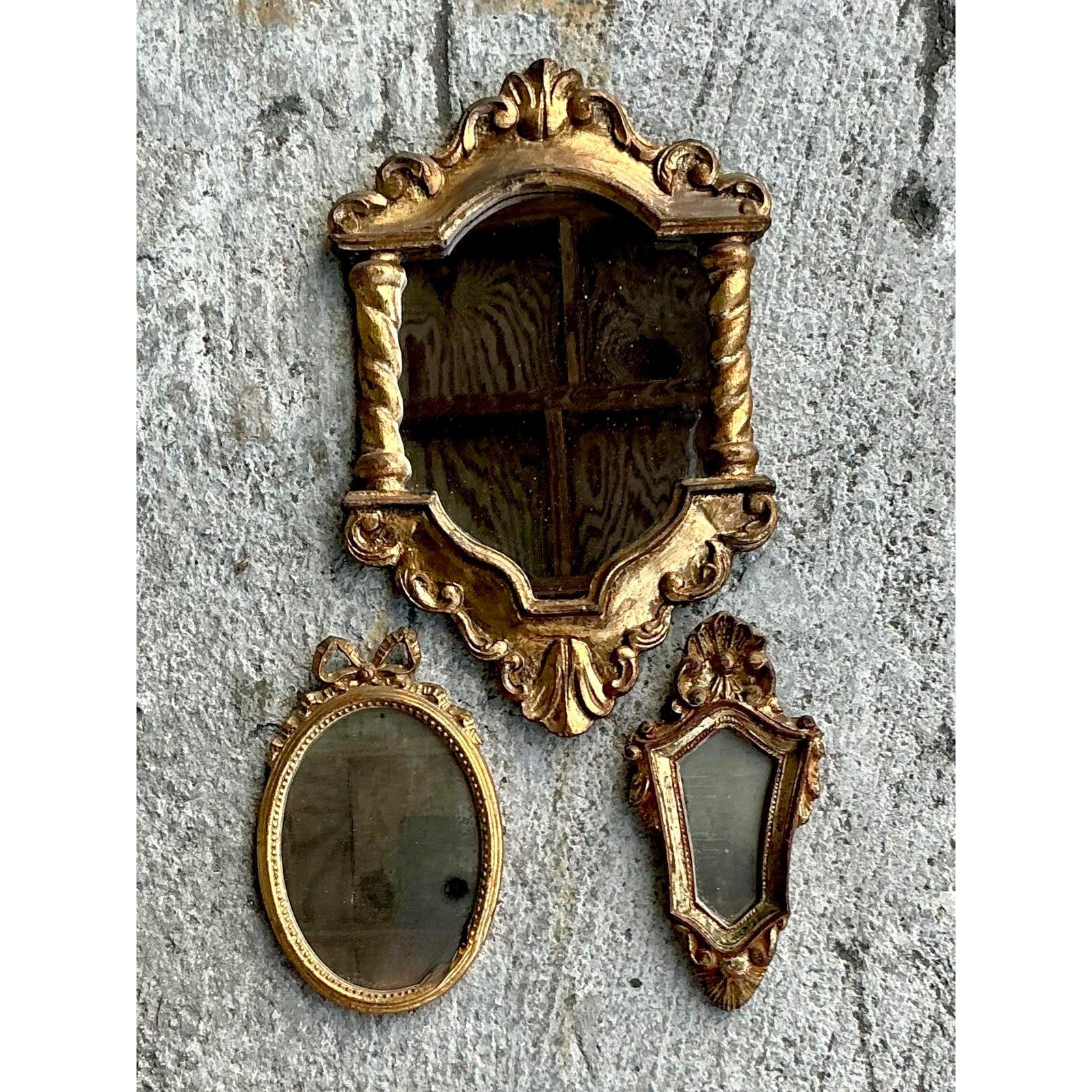 Valorizza la tua casa con questo raffinato set di tre specchi dorati italiani vintage, ognuno dei quali ha un design unico con intricati dettagli di ispirazione barocca. Caratterizzati da ornati a volute, colonne tortili e abbellimenti decorativi,