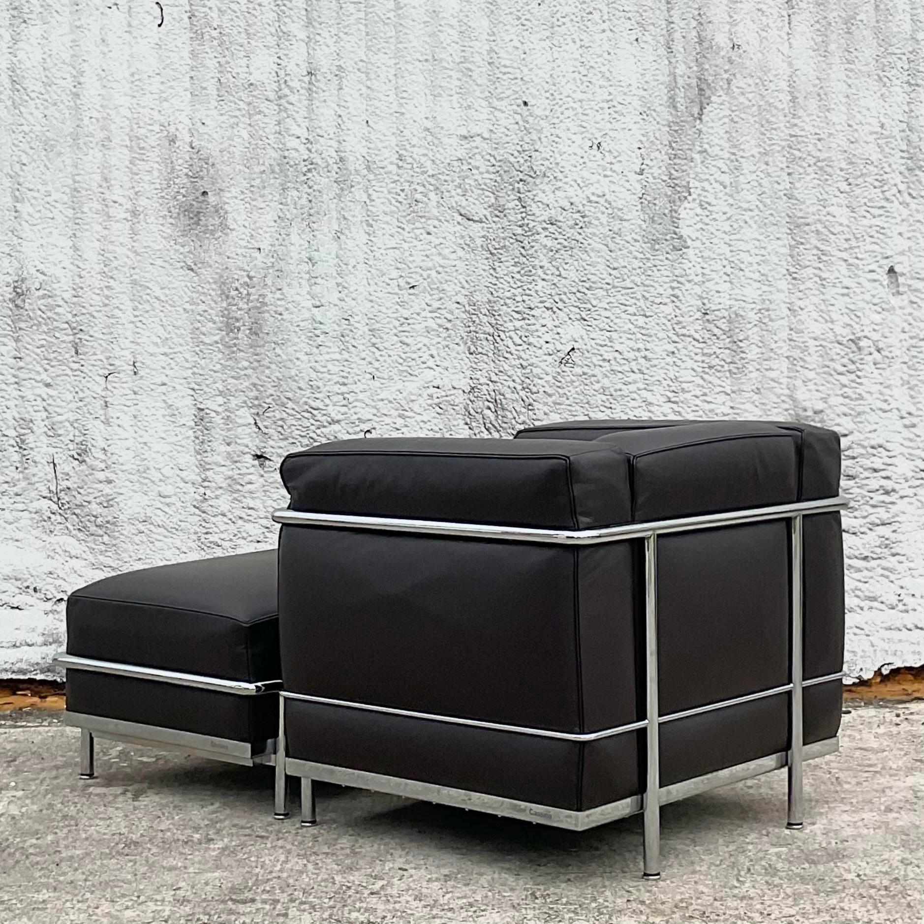 A fantastic vintage Contemporary chair and ottoman. Made in Italy by the Cassina group and tagged below. The classic Petite Modele design. Chic dark charcoal leather in the iconic Le Corbusier shape. Acquired from a Palm Beach estate.

Ottoman
