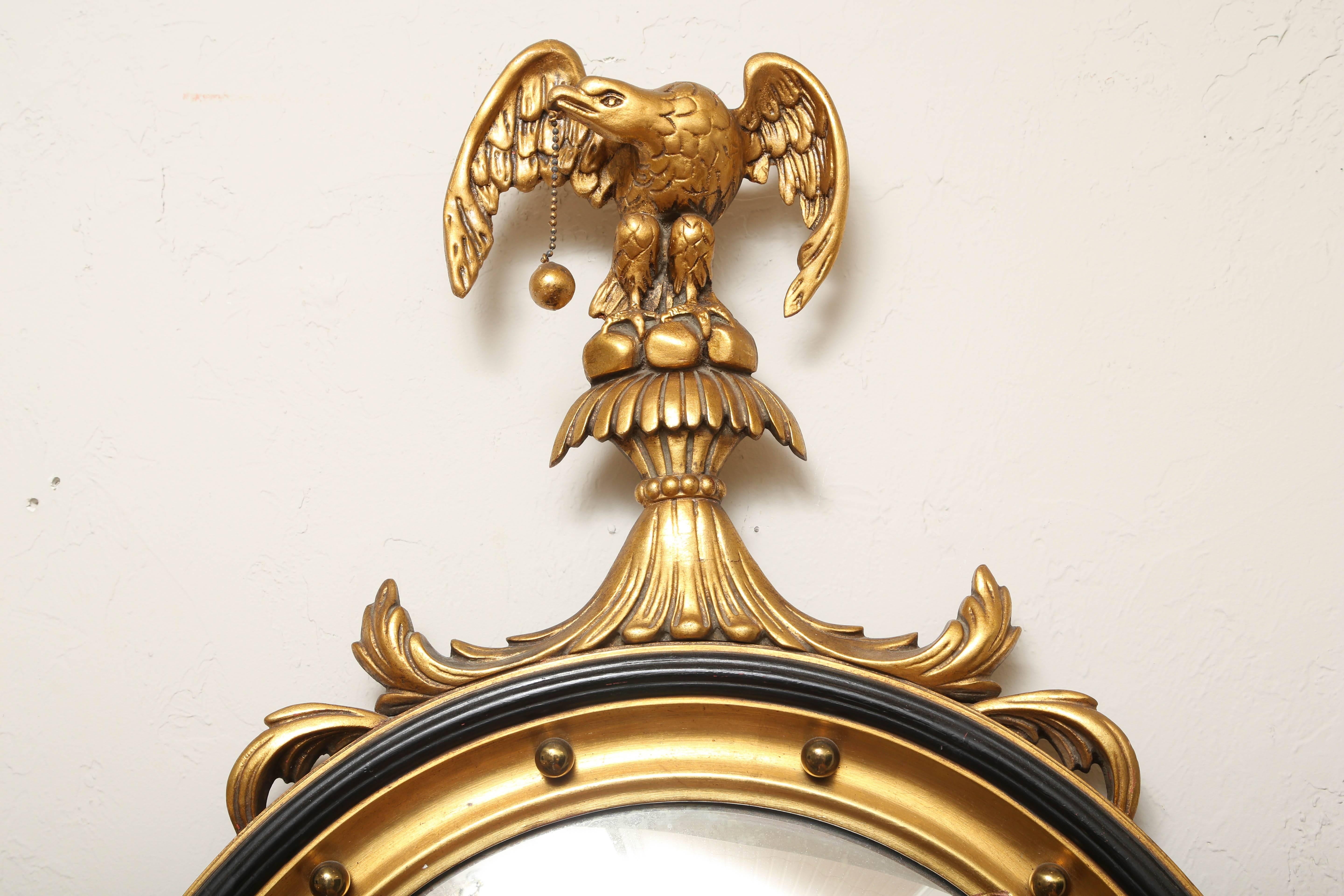 Classical convex gilded mirror with eagle on top.