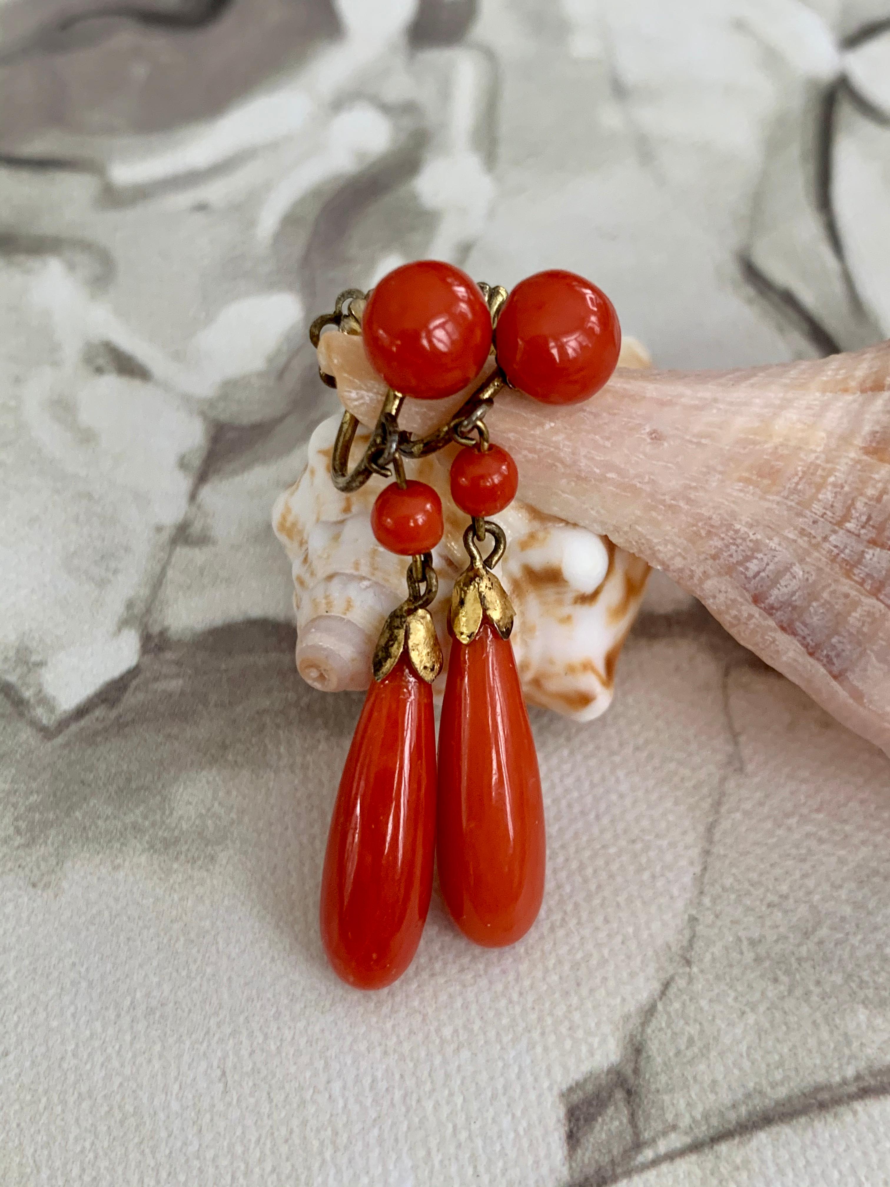 These beautiful Italian dangle earrings feature teardrop-shaped coral.  Each earring also has two additional round graduated Coral stones.  The backs are screw back and are made of Silver.

Length:  1 3/4
