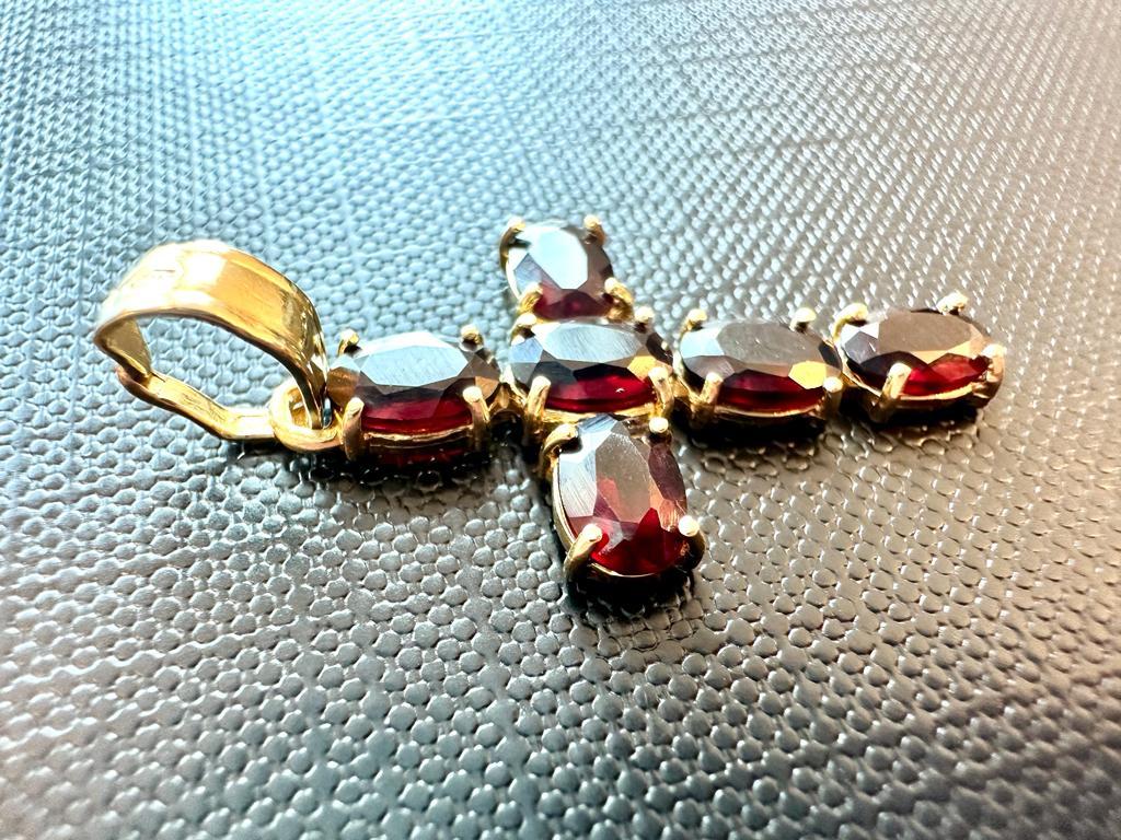 This beautiful italian vintage cross pendant is crafted in 18kt yellow gold and is fully decorated with 6 oval cut garnets totaling 1.8ct. There are over 15 garnet species but only 6 varieties are most commonly used as gems. This gem was very
