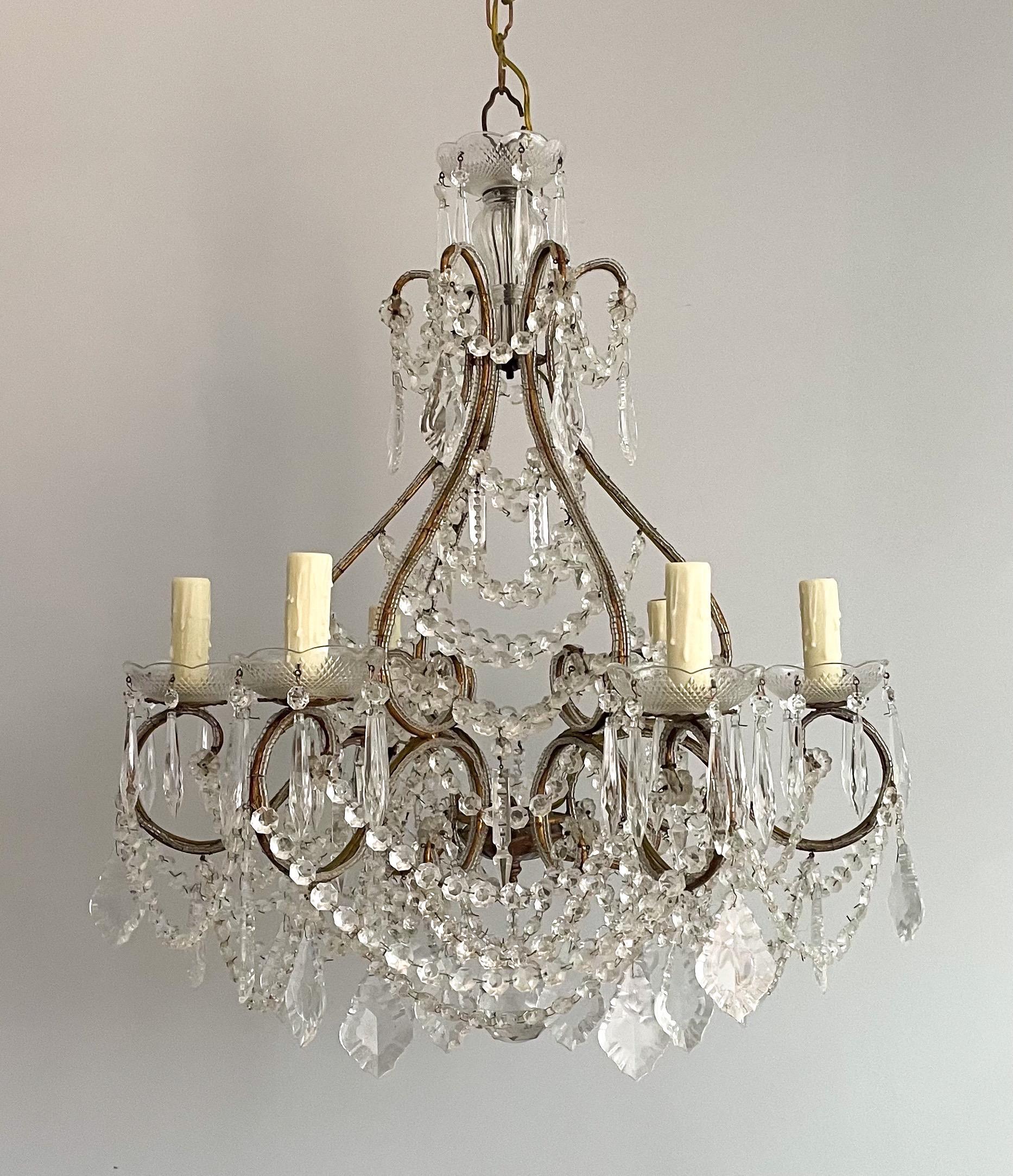 Gorgeous, 1940s Italian gilded iron and crystal beaded chandelier.

 The scrolled iron frame of this chandelier features a beautiful gilt finish with tiny glass beads outlining its entirety. Garlands of crystal beads and shapely prisms complete
