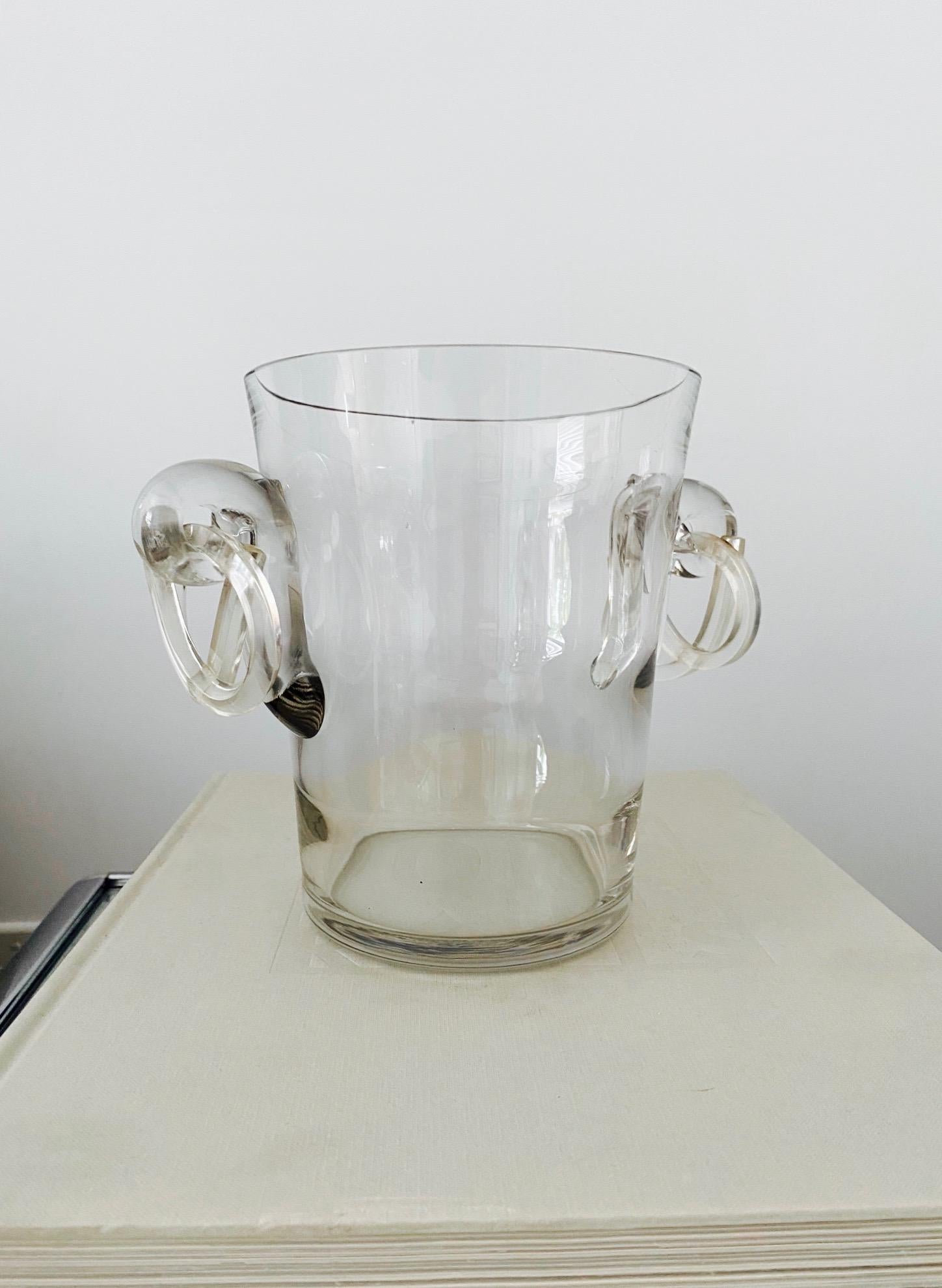 Italian Mid-Century Modern crystal ice bucket or champagne cooler with stylized pretzel handles in lucite. The cooler has a slight tapered form with horizontal fluted details and features blown glass scrolls on either side. All handcrafted with