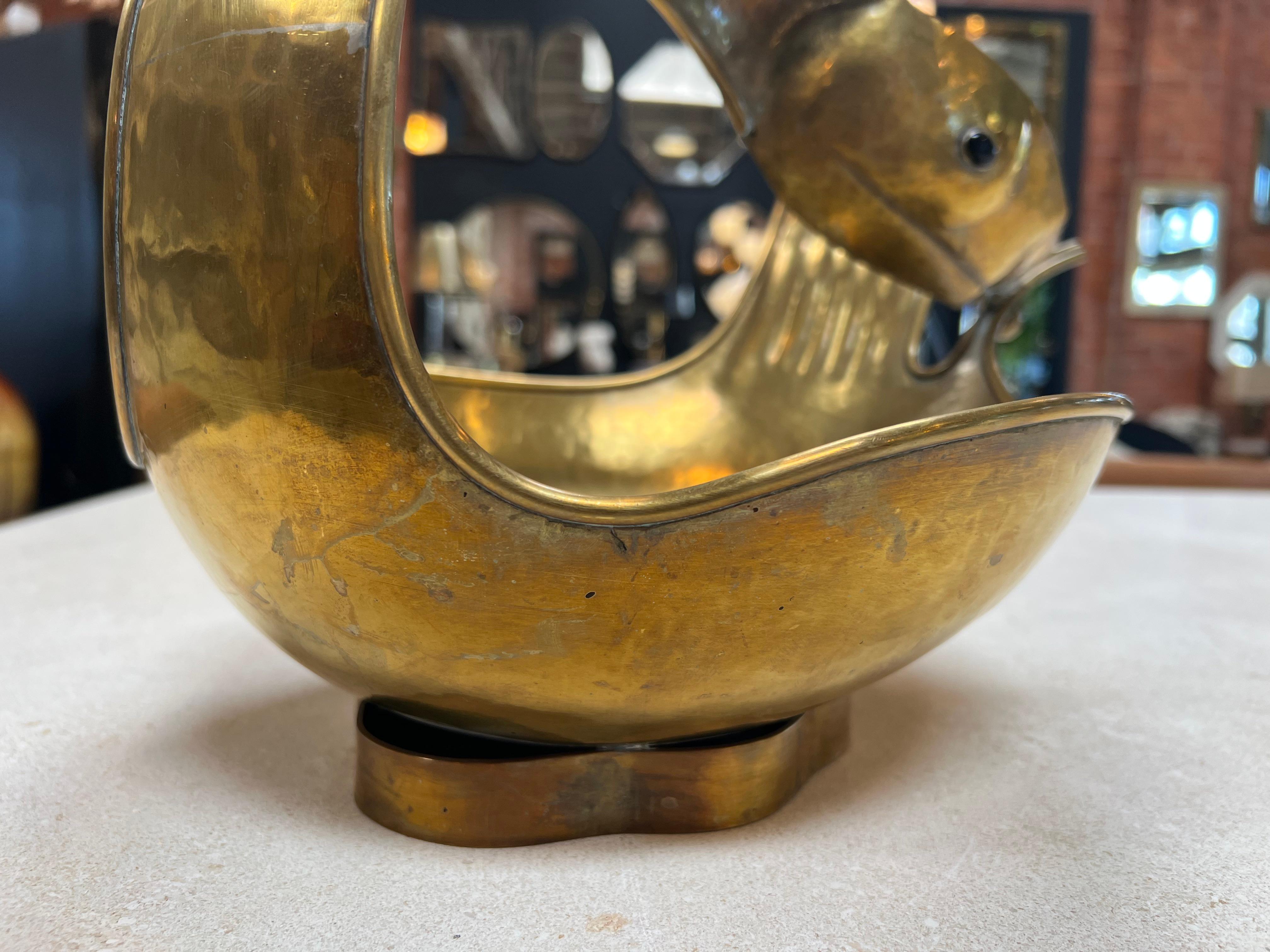 The Vintage Italian Brass Center Bowl from the 1960s captures the essence of Italian design with its timeless appeal. Crafted from brass, this piece exudes a warm and lustrous aura that adds a touch of luxury to any space. The bowl's design