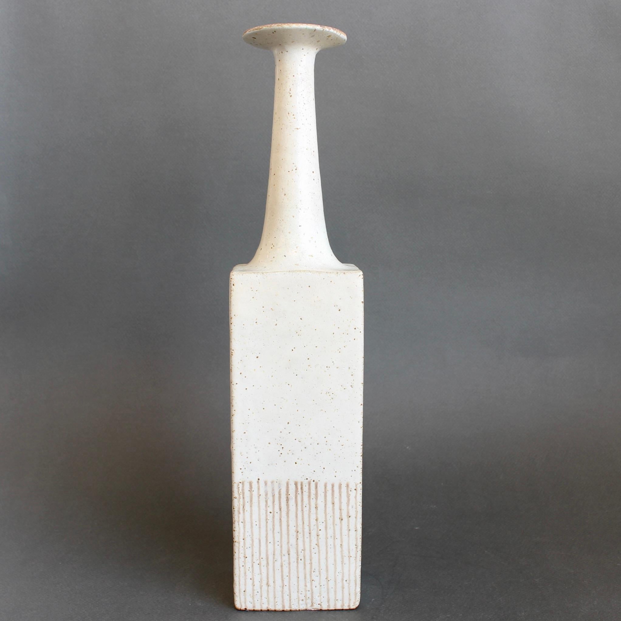 Bottiglia decorativa in ceramica / vaso a fiore singolo di Bruno Gambone (circa anni '80) con superficie bianco gesso con macchie color farina d'avena sul corpo principale. La sezione inferiore presenta una serie di linee che colano verso la base