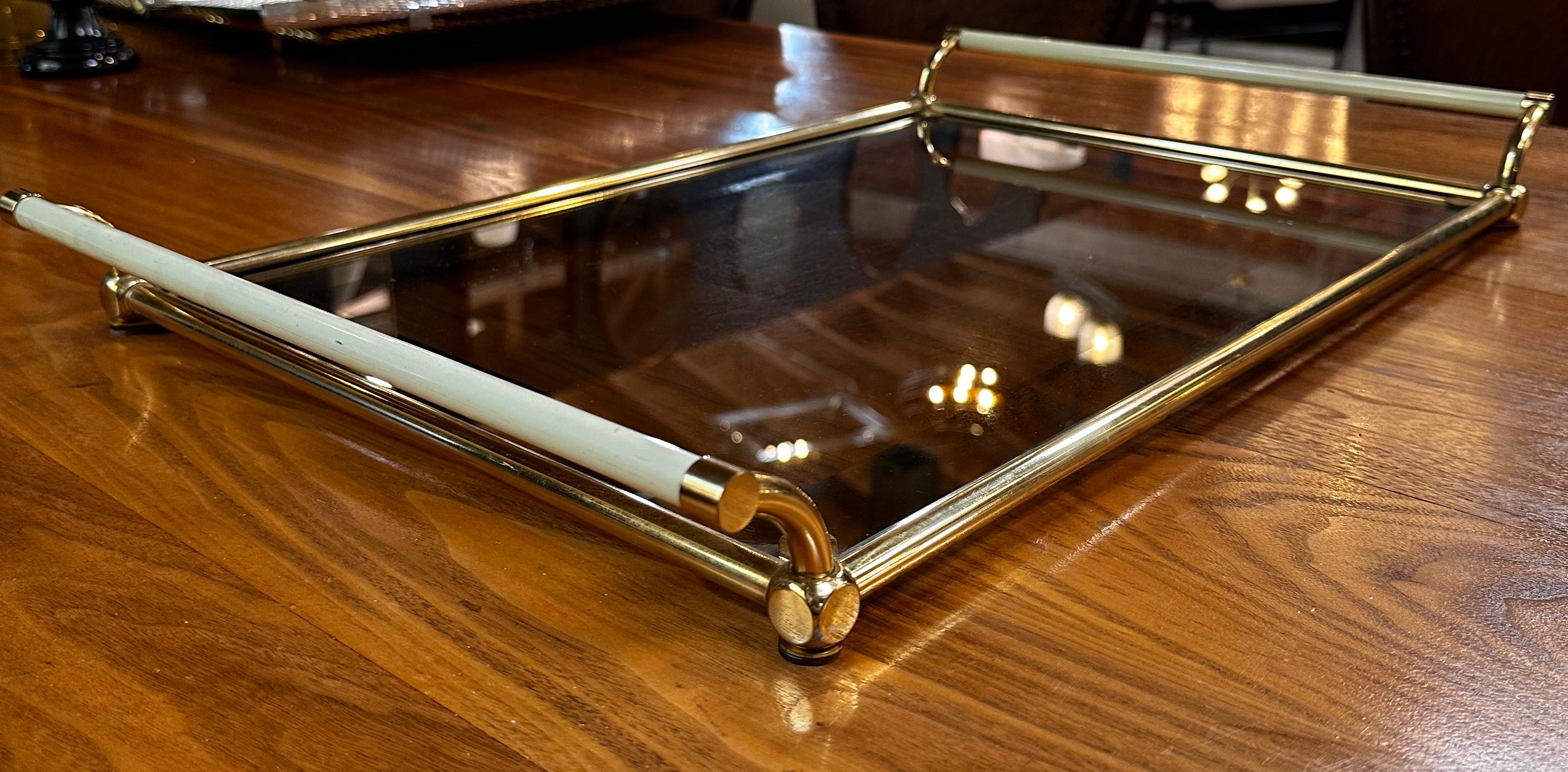 A Vintage Italian Decorative Rectangular Tray from the 1980s features a brass frame, a glass base, and elegant white handles. This tray exemplifies 1980s Italian design, combining sleek materials and clean lines for a stylish and sophisticated