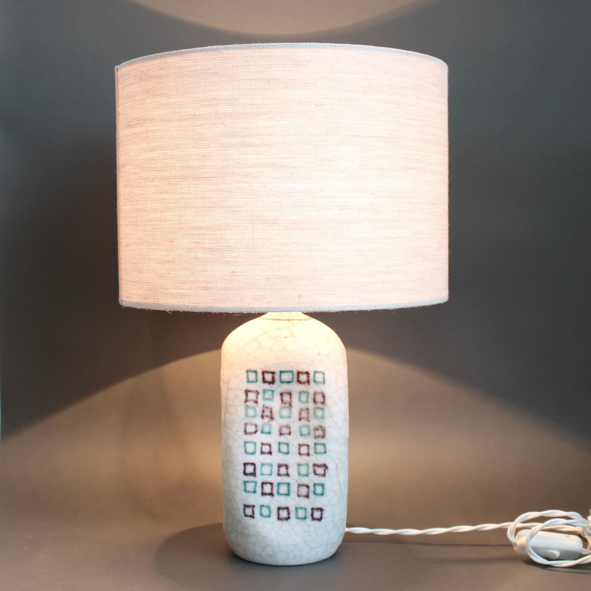 Lampada da tavolo decorativa in ceramica italiana di Guido Gambone (circa anni '50). Il pezzo è dipinto a mano con un morbido smalto bianco latte con effetto craquelure. In due delle nicchie centrali, troverai un motivo a quadrati ripetuti, come le