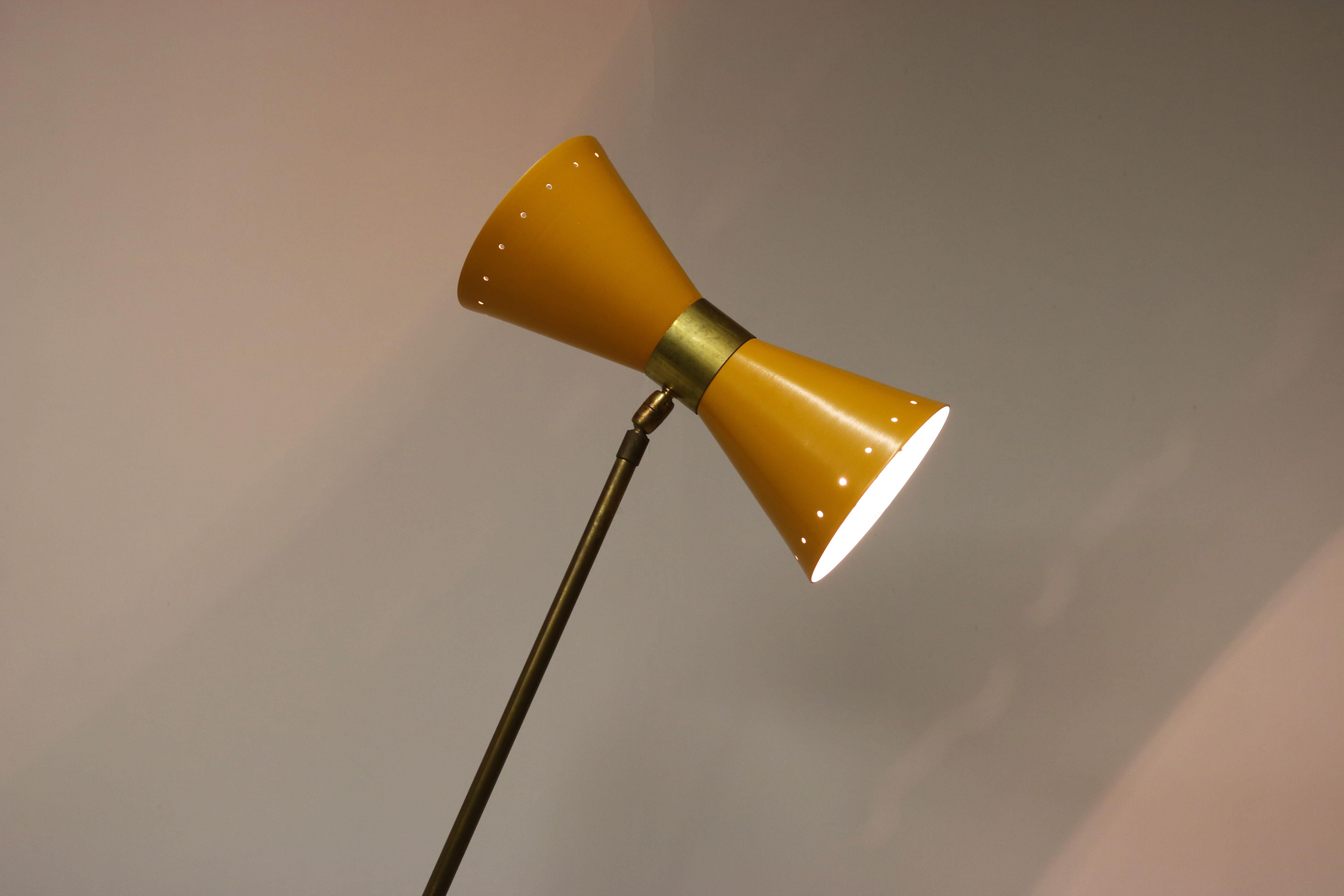 Magnifique lampadaire minimaliste au design italien dans le style de Stilnovo 1950. 
Cadre en laiton patiné avec base au design minimaliste unique. Magnifique abat-jour jaune en forme de diabolo. Un design intemporel ! 
L'angle du lampadaire et de