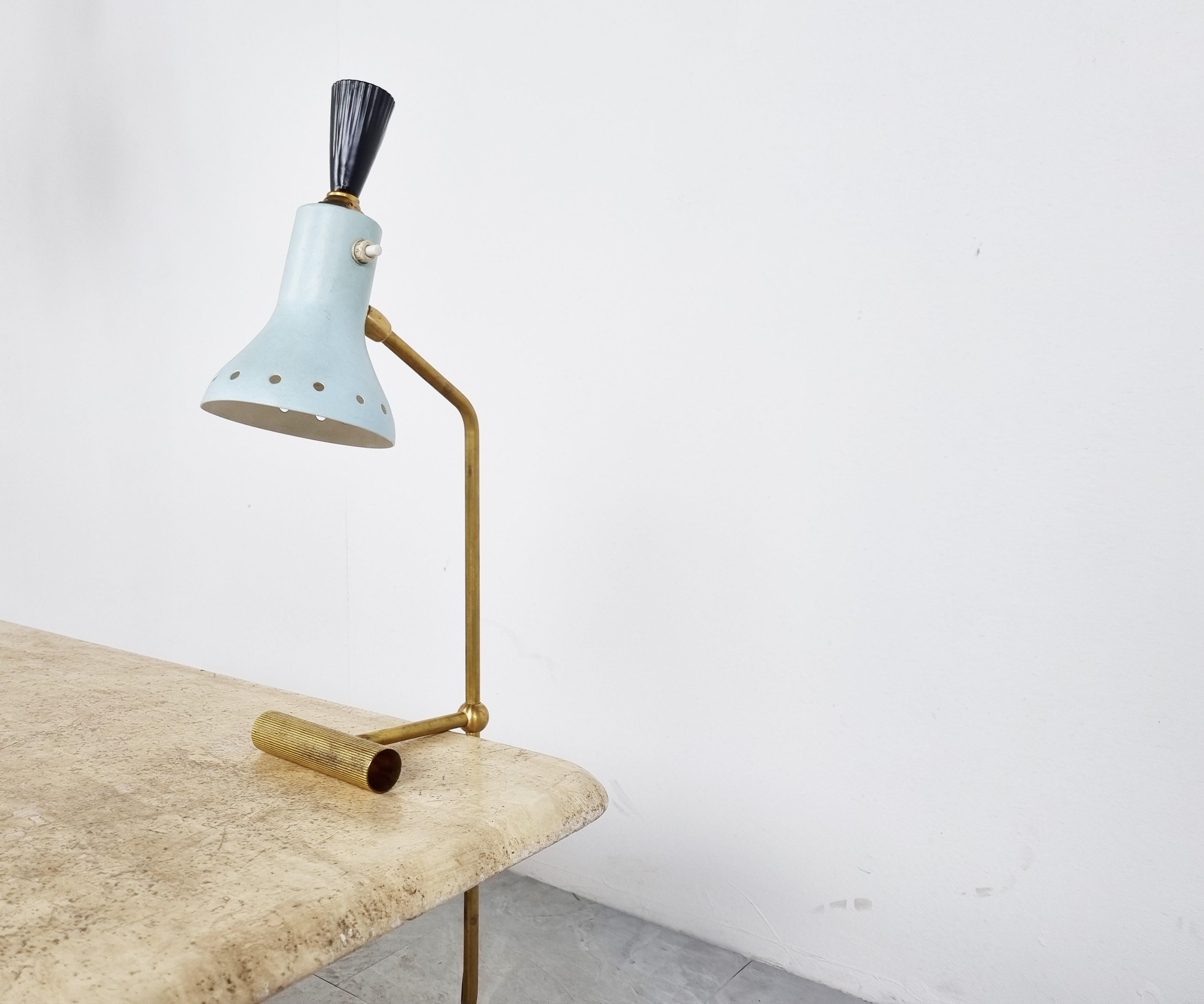 Unusual mid century counter balancing table lamp with a diabolo shaped lamp shade.

Beautiful light blue colour and patinated brass arm/base.

The smart design uses a brass counter wheight to keep the lamp stable.

The lamp shade is adjustable