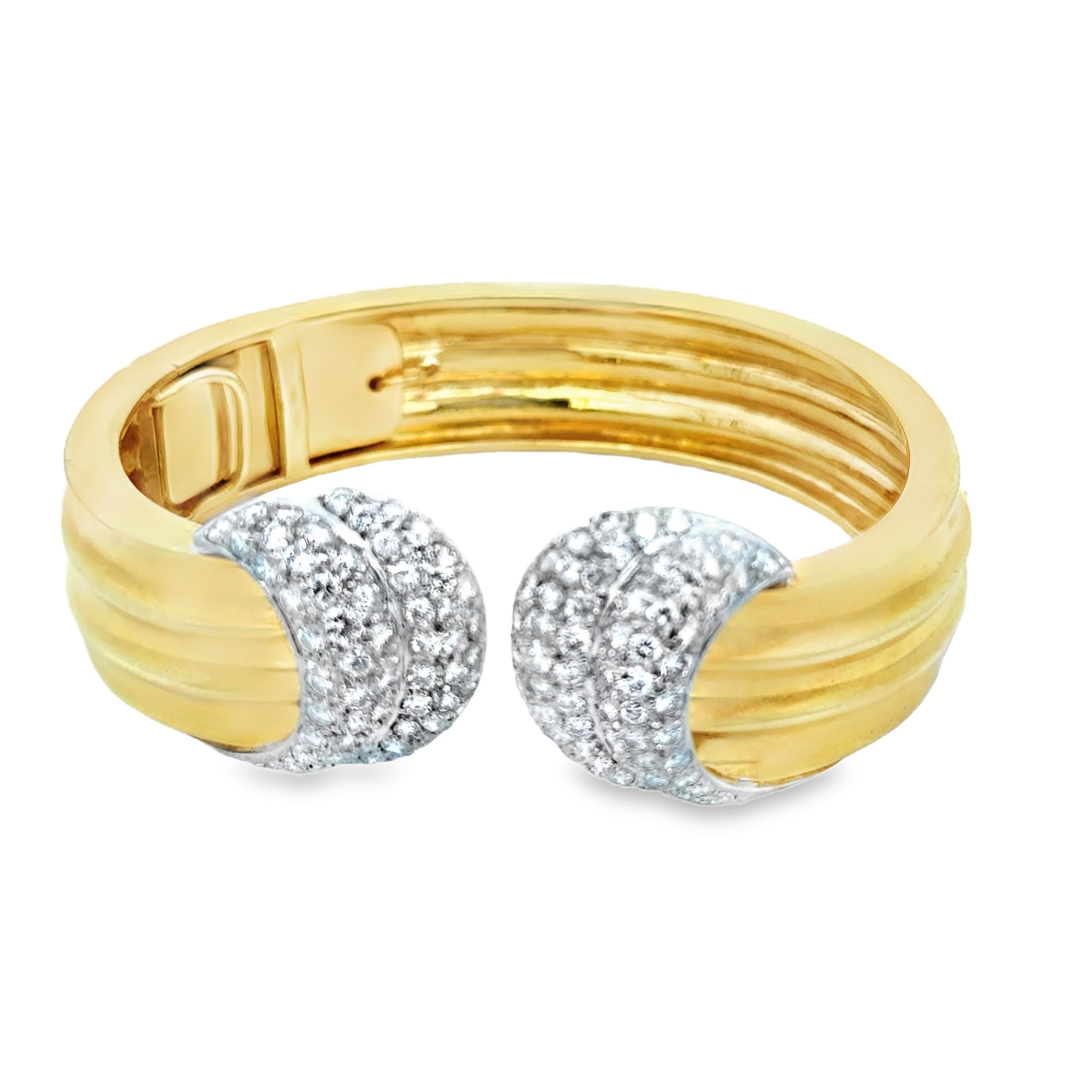 This striking vintage bangle bracelet, crafted in Italy circa 1980, is a bold and timeless example of fine Italian jewelry design. Made of solid 18K yellow gold and platinum, it features two crescent-shaped platinum end caps set with approximately