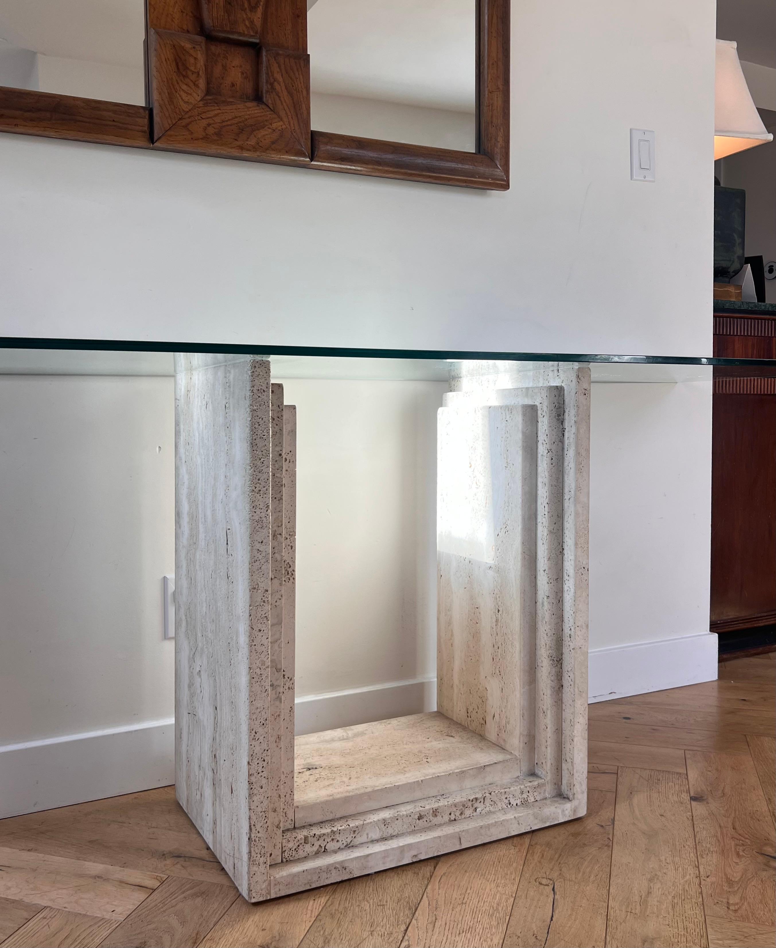 A monumental vintage Italian « Diapason » console table by Cattelan Italia, circa 1986. Featuring a solid travertine base graduated in the style of architect and designer Carlo Scarpa. The unbeveled glass top is original. An heirloom piece for the