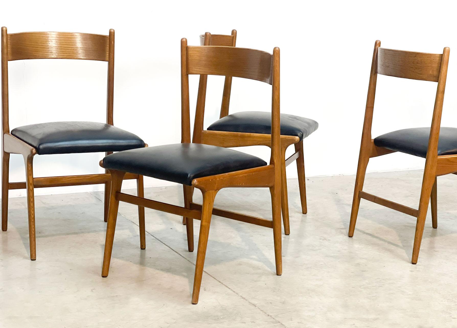 Elegant mid century italian dining chairs with wooden frames and black leatherette upholstery.

Good condition

1960s - Italy

Dimensions:
Height: 74cm/29.13