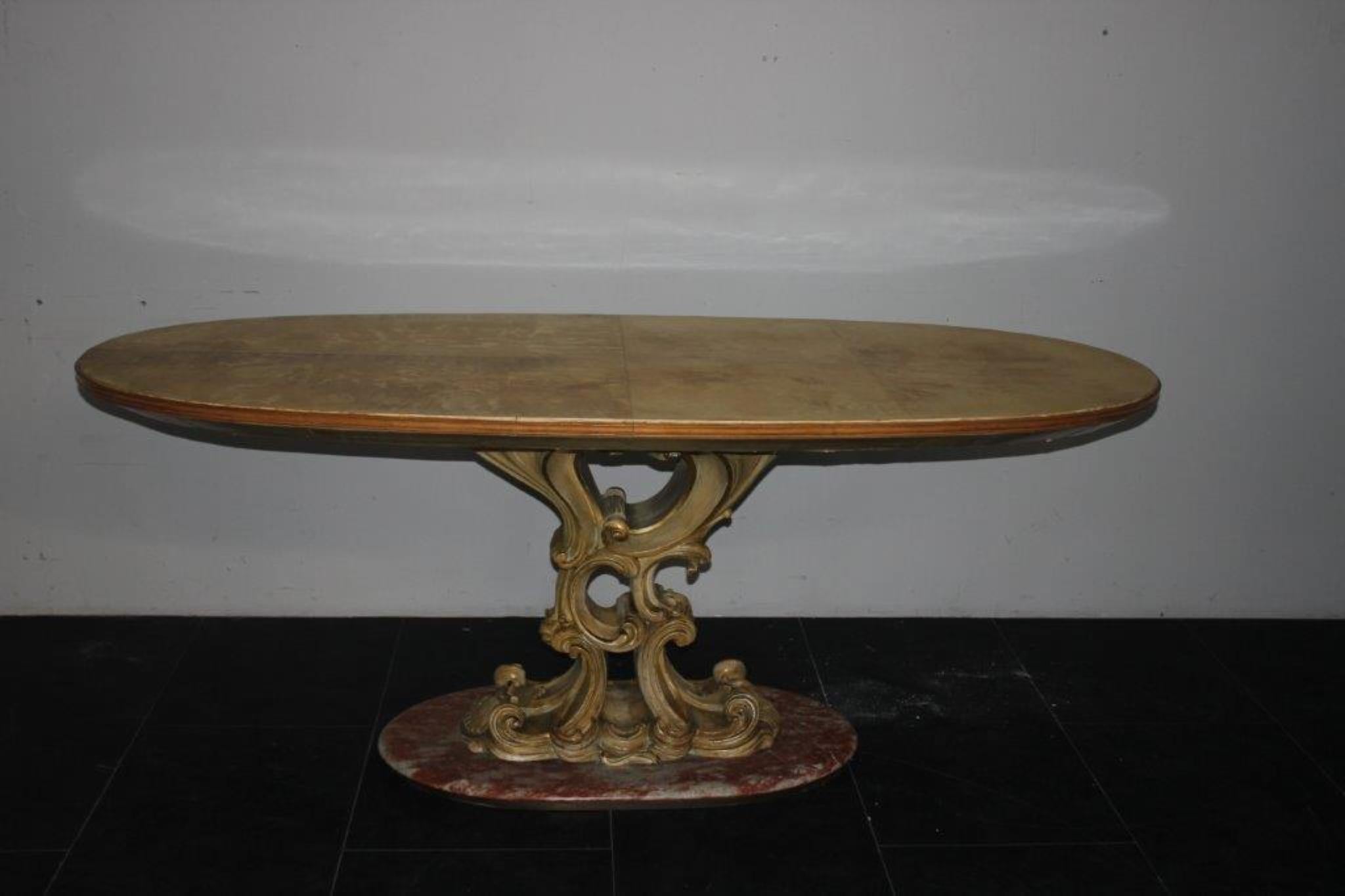 Table 1940 of the Permanente Cantù, from the base in red marble of France starts a curvilinear ridge in baroque style in carved and lacquered wood. The plan of art deco taste is oval of generous depth the underside covered in parchment follows a