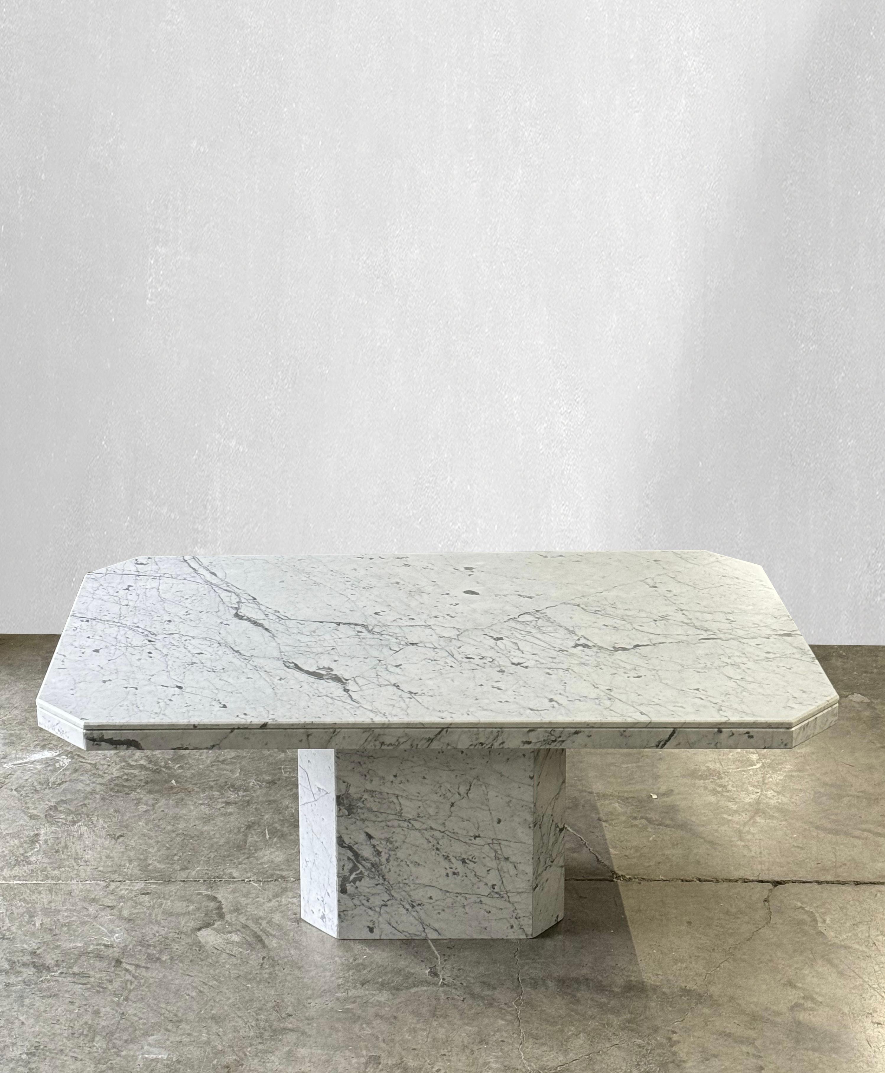 C. 1970

Monumental Carrara marble dining table with matching base.

Stunning veining throughout the solid Carrara marble top and base. This table has  unique angled corners. The matching pedestal base also has beautiful angles. Comfortably seats 6
