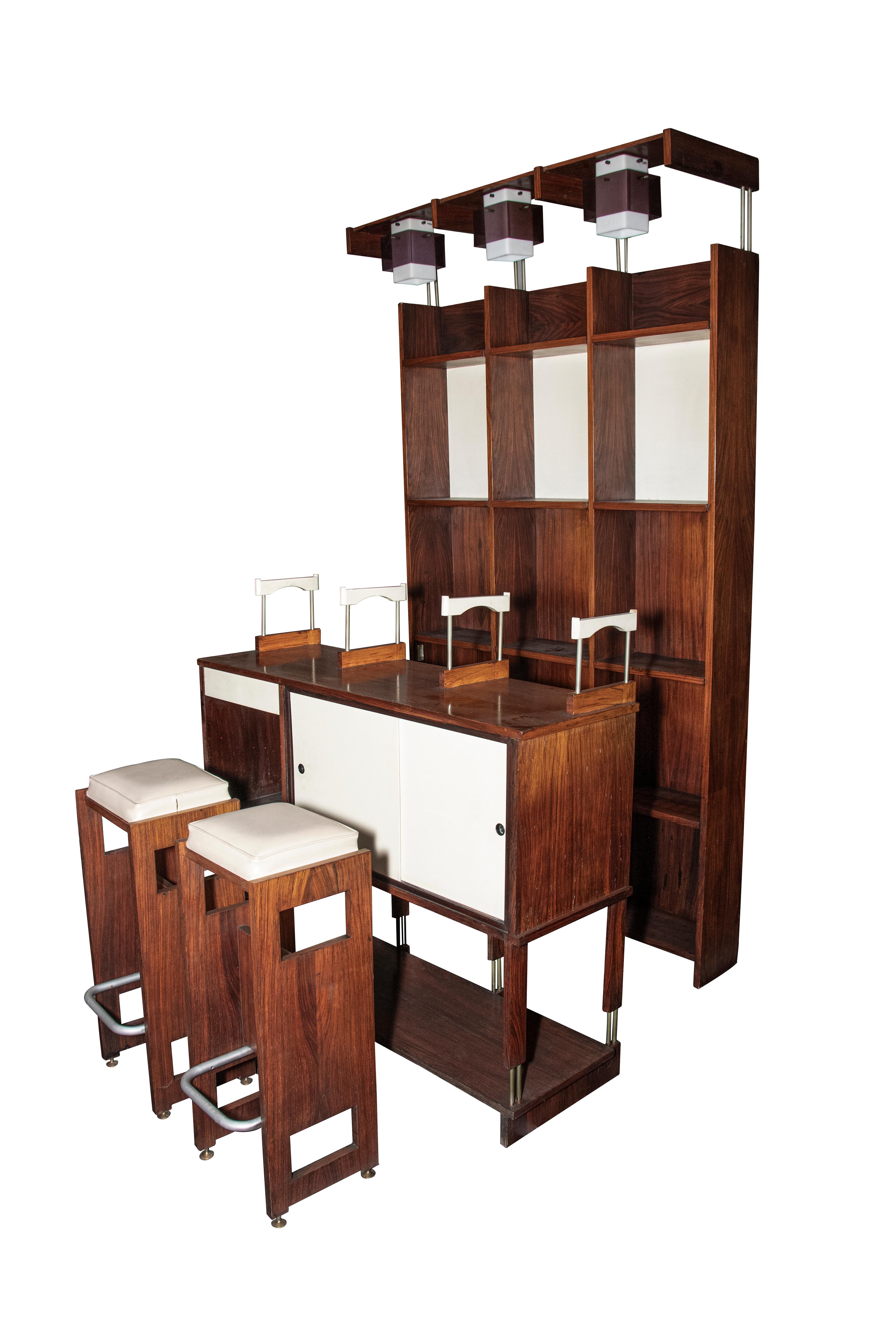 Vintage Italian dry bar is an item of original design furniture realized in the 1950s by Italian Manufacture.

The item is composed of a bar counter, wall unit, and two stools.

Walnut veneer core plywood, brass, lacquered wood, cut crystal. Opal
