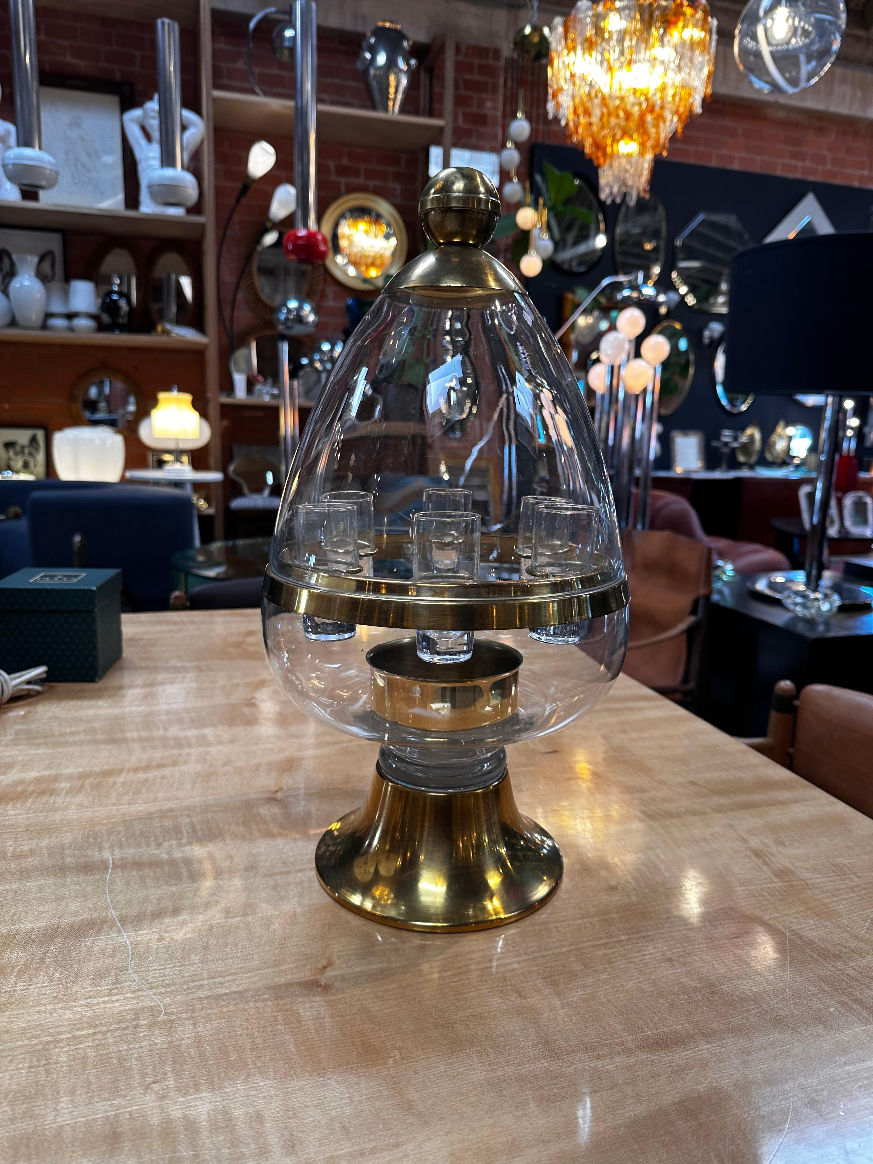The Vintage Italian Egg Decanter Liquor Shot Glass Case from the 1960s is a multifunctional and stylish barware accessory. Crafted with a brass base and a glass top, it features a unique egg-shaped design that adds a touch of retro charm. This