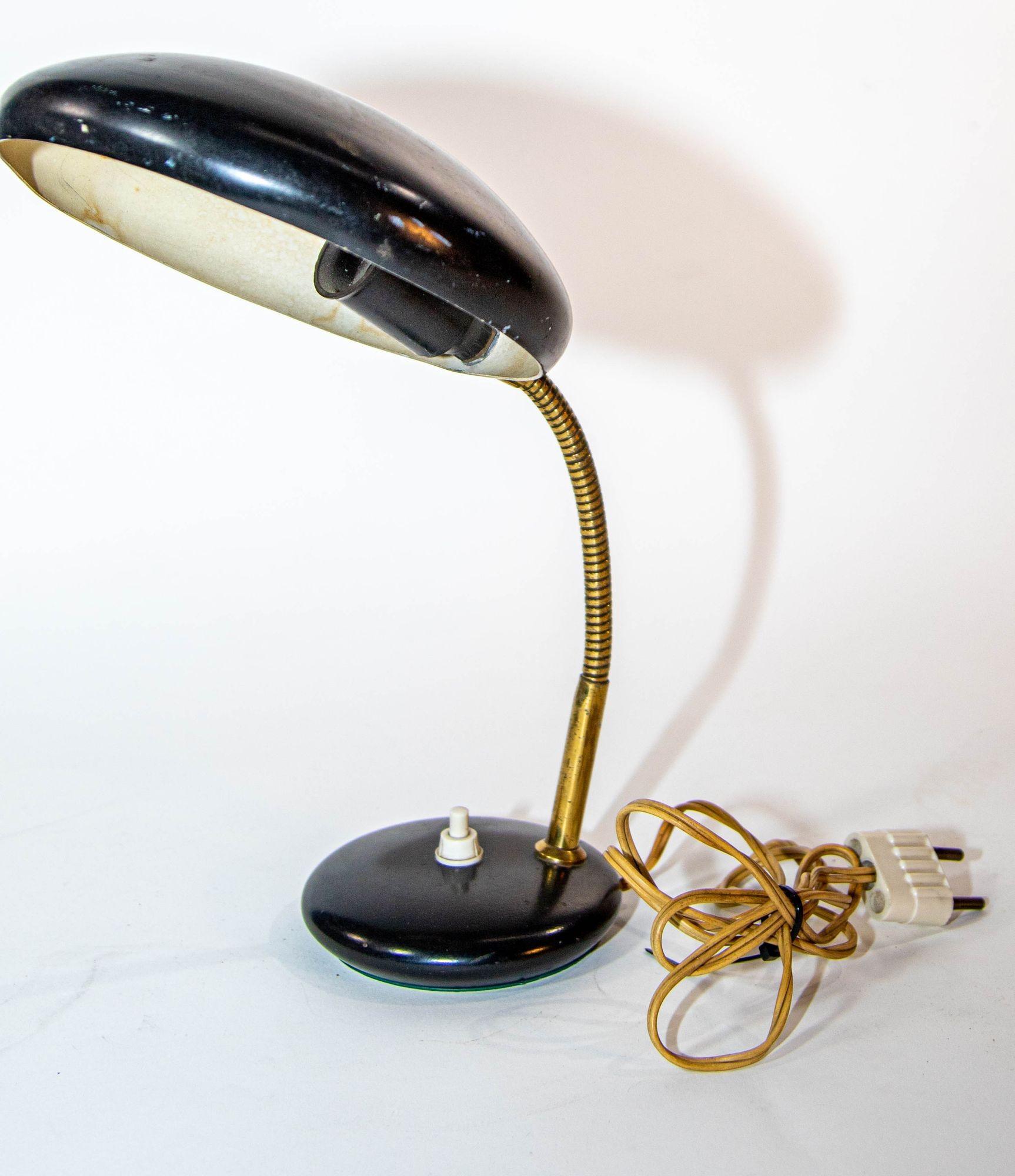 Vintage 1950s Italian Enameled Tole and Brass Desk Lamp, Bauhaus Style.
This exquisite vintage European petite desk lamp showcases a classic Bauhaus design, featuring a gooseneck arm and a flying saucer shaped shade.
The lamp's shade and base are