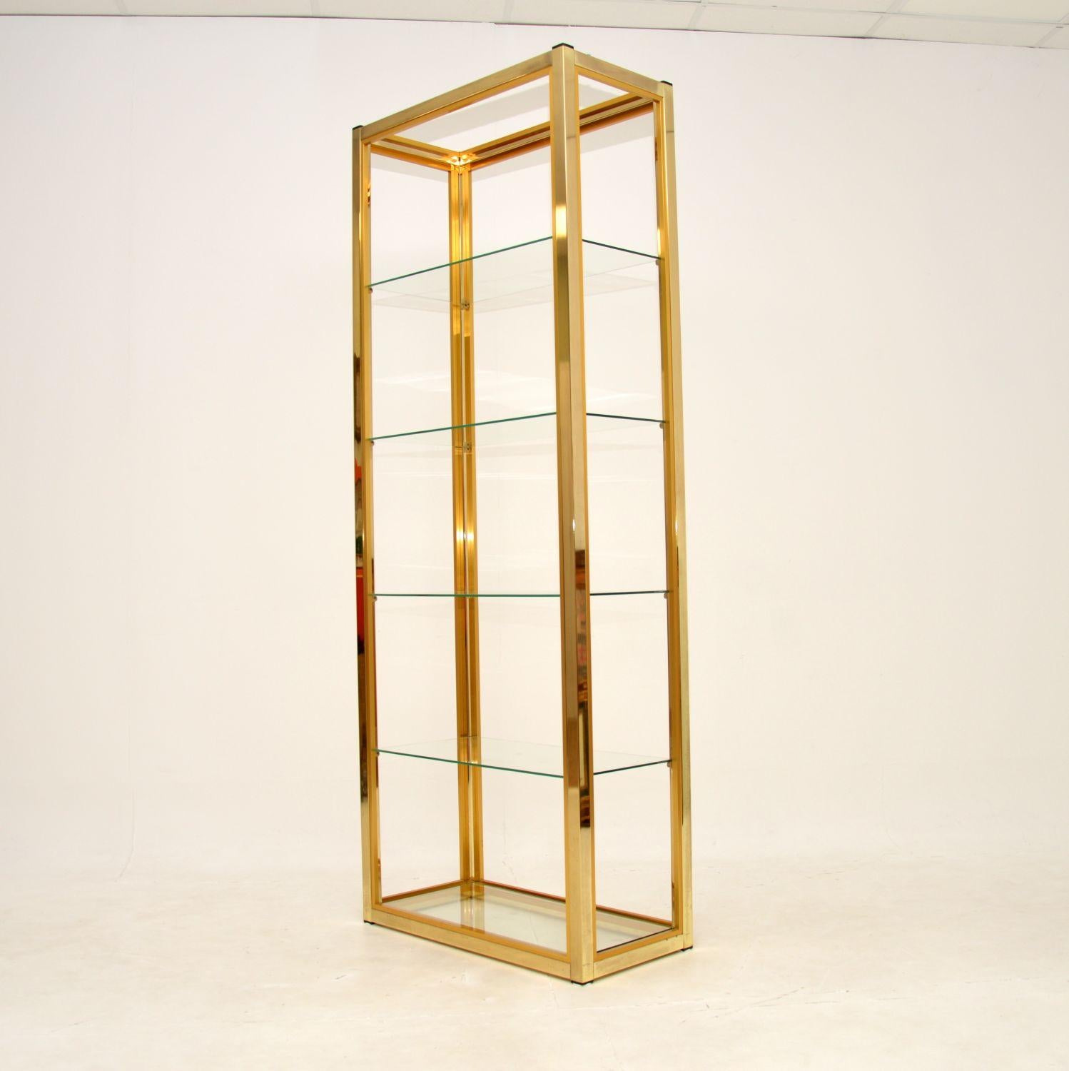 A stunning vintage Italian etagere display cabinet by Zevi. This was designed by Renato Zevi, it was made in Italy in the 1970’s.

This is the less commonly seen version in completely gold finish, it is brass plated aluminium. The quality is
