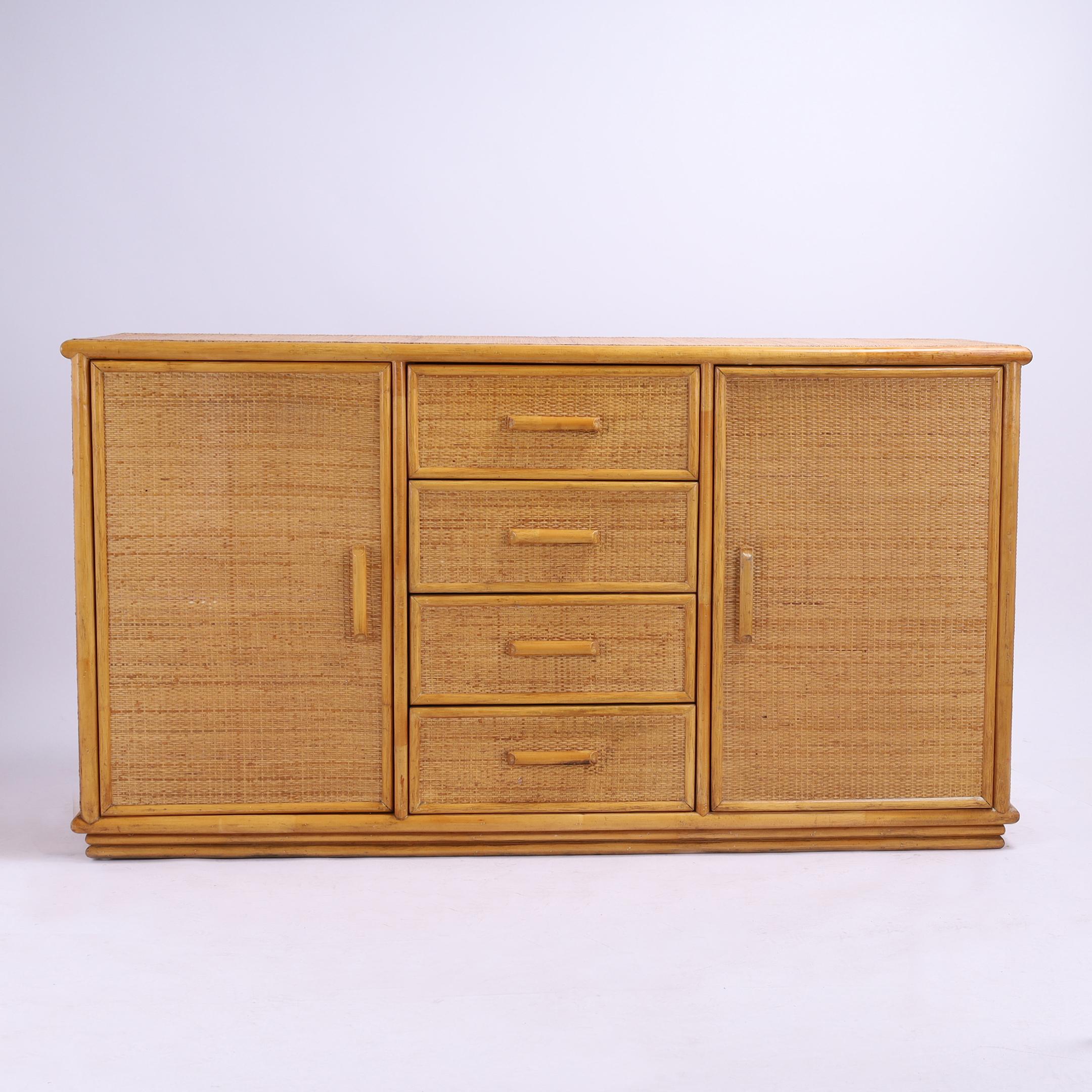 Credenza o credenza della metà del secolo scorso realizzata con un'eleganza informale grazie alla struttura in finto bambù e ai pannelli in tela d'erba su tutto il perimetro, con quattro cassetti affiancati da ante per un ampio spazio di