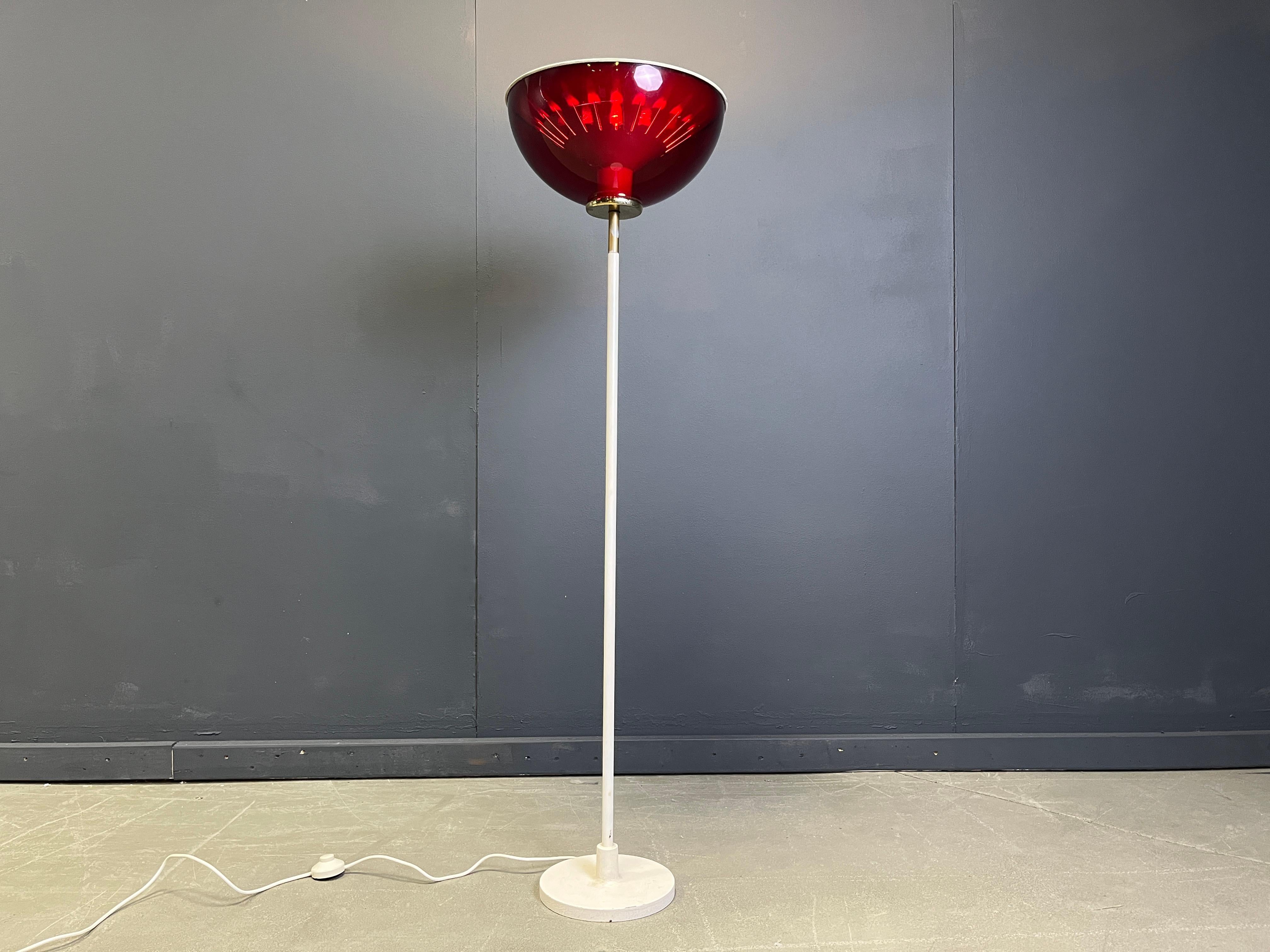 Mid century italian floor lamp attributed to Stilnovo with a white metal base with brass hardware and a red plastic shade with the original metal reflector.

Beautiful space age floor lamp which emits a nice warm light.

1960s, Italy

Good condition