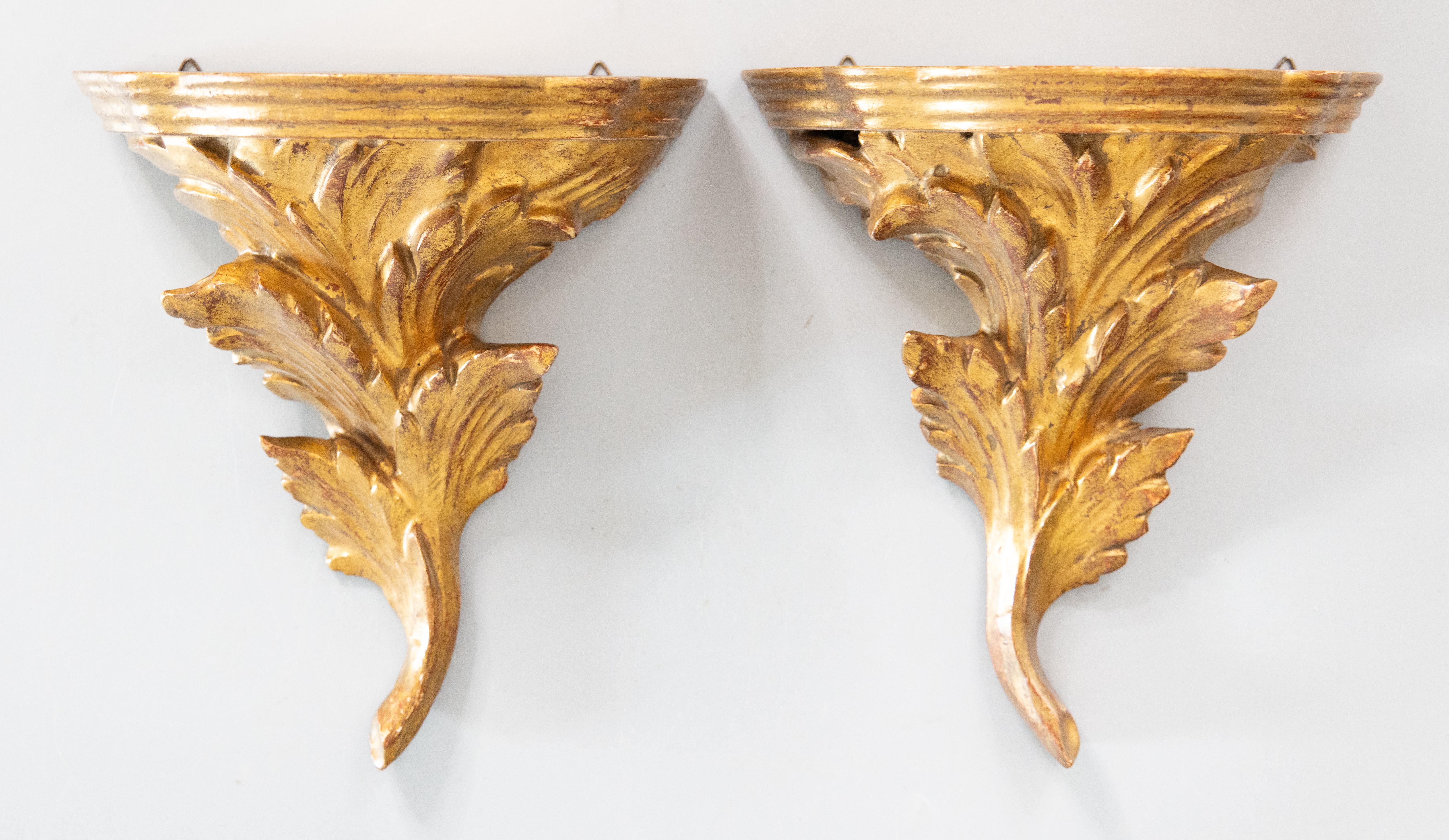 Precioso par de ménsulas o estantes de pared italianos vintage de madera dorada y gesso, procedentes de Florencia, Italia, hacia 1950. Estas elegantes escuadras tienen un diseño de hojas de acanto talladas a mano y una hermosa pátina dorada. Son