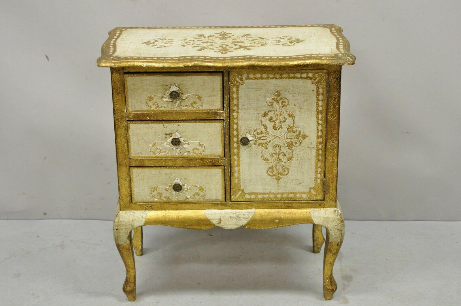 Vintage Italian florentine cream and gold small nightstand side table cabinet. Item features a gold gilt Florentine details, cream and gold painted finish, nice small size, 1 swing door, 3 drawers. Circa mid-20th century. Measurements: 27.5