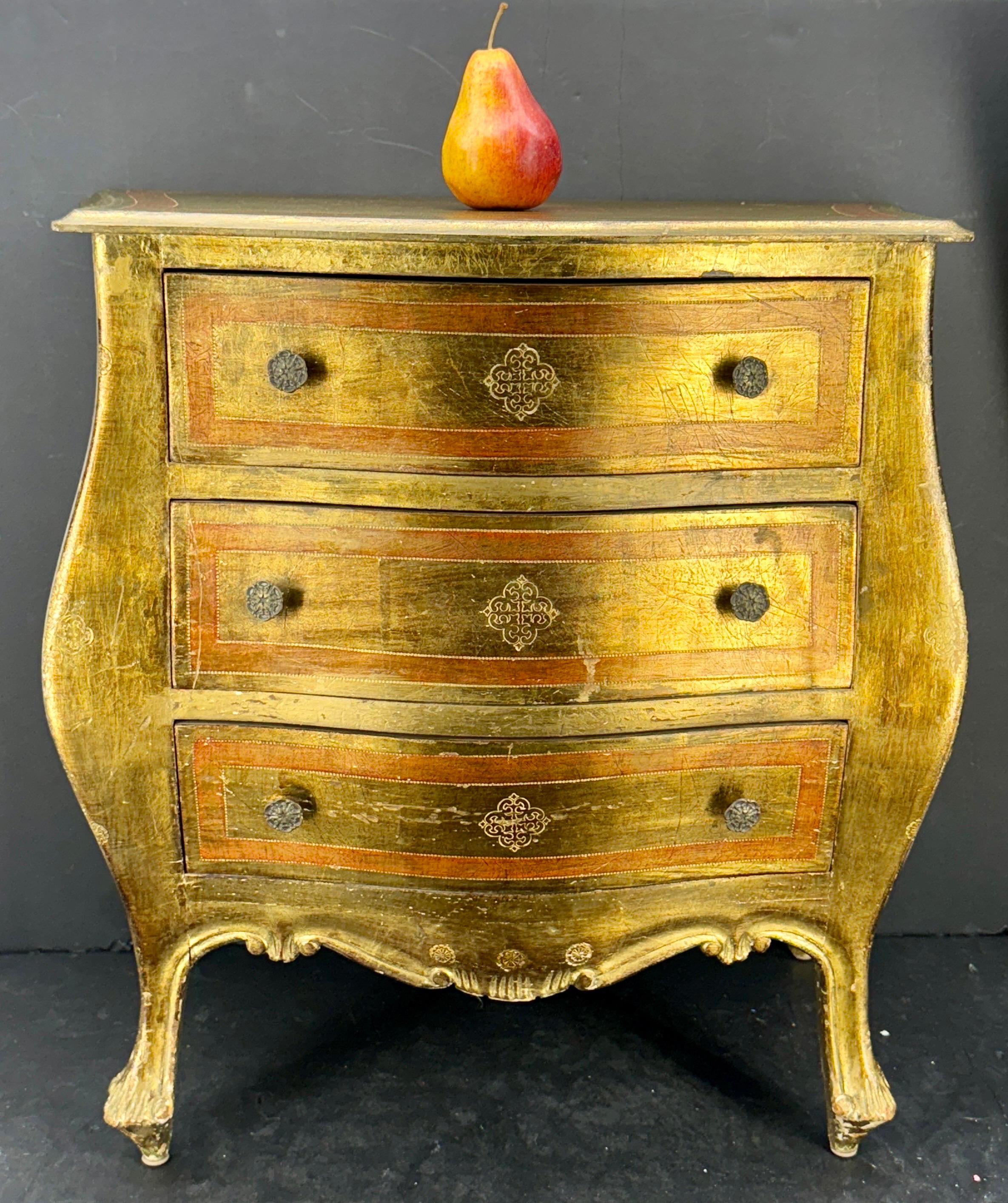 Fabulosa mesilla de noche florentina de tres cajones con bandas de color naranja/óxido, así como detalles dorados y patas cabriolé, marcada Made in Italy. Este baúl es una pieza muy versátil que puede utilizarse como mesa auxiliar en un salón,