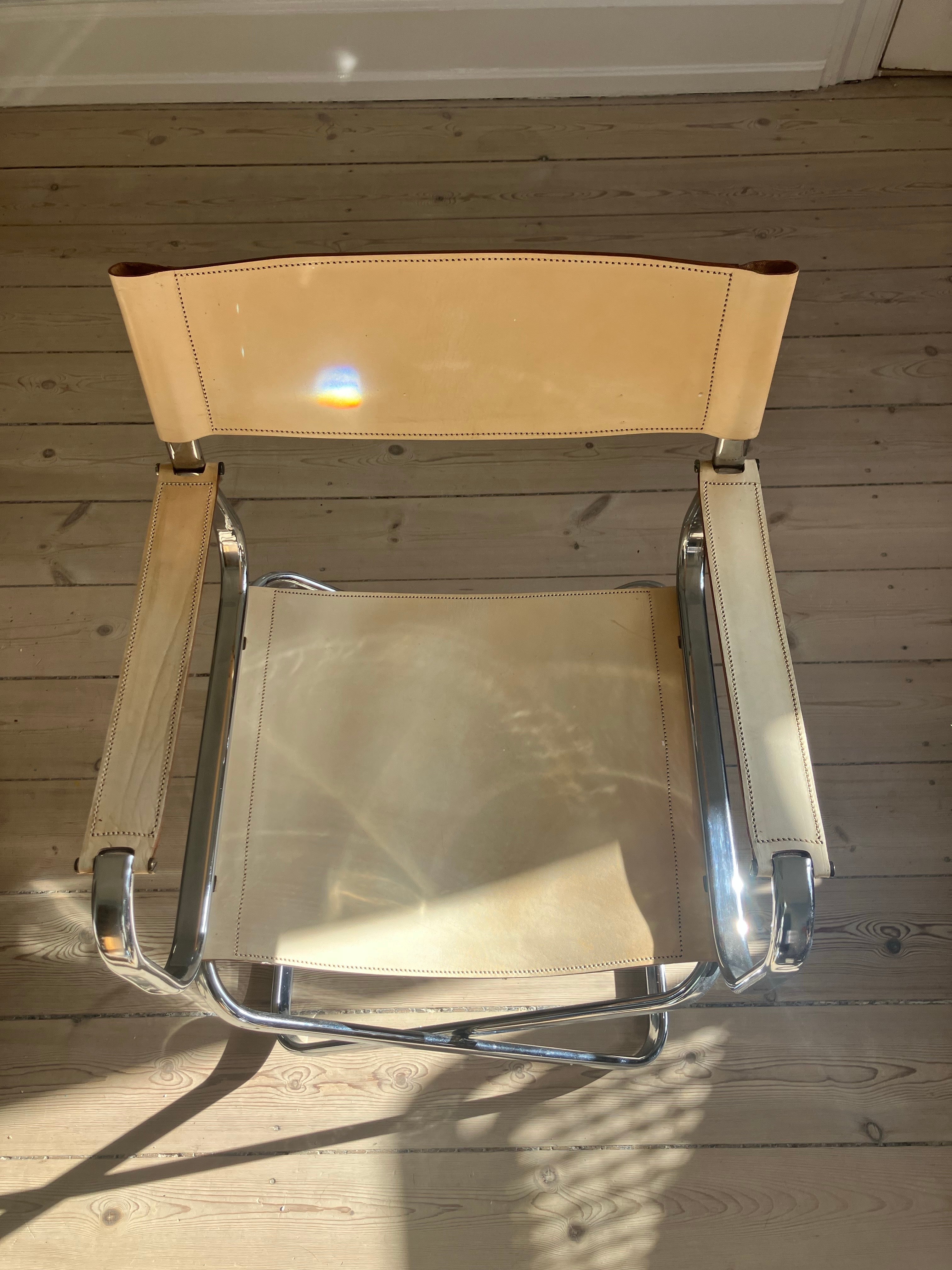 Italienischer Klappstuhl aus den 1970er Jahren mit verchromtem Rohrgestell und beigem Leder in Sitz und Rücken. 

Der Stuhl kann leicht gefaltet werden und nimmt daher im zusammengeklappten Zustand nicht viel Platz ein. 

Der Chromrahmen ist in