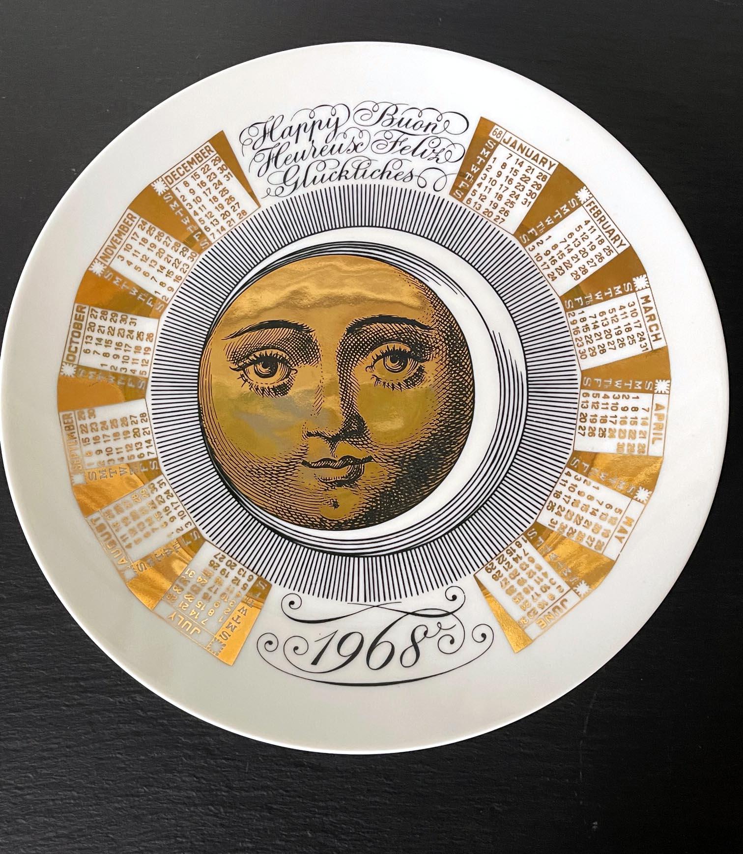 A vintage Italian decorative porcelain plate designed by Piero Fornasetti and made by Fornasetti. The commemorative plate is for the year of 1968 and features the iconic sun and moon motif by the artist surrounded by the monthly calendar. The back