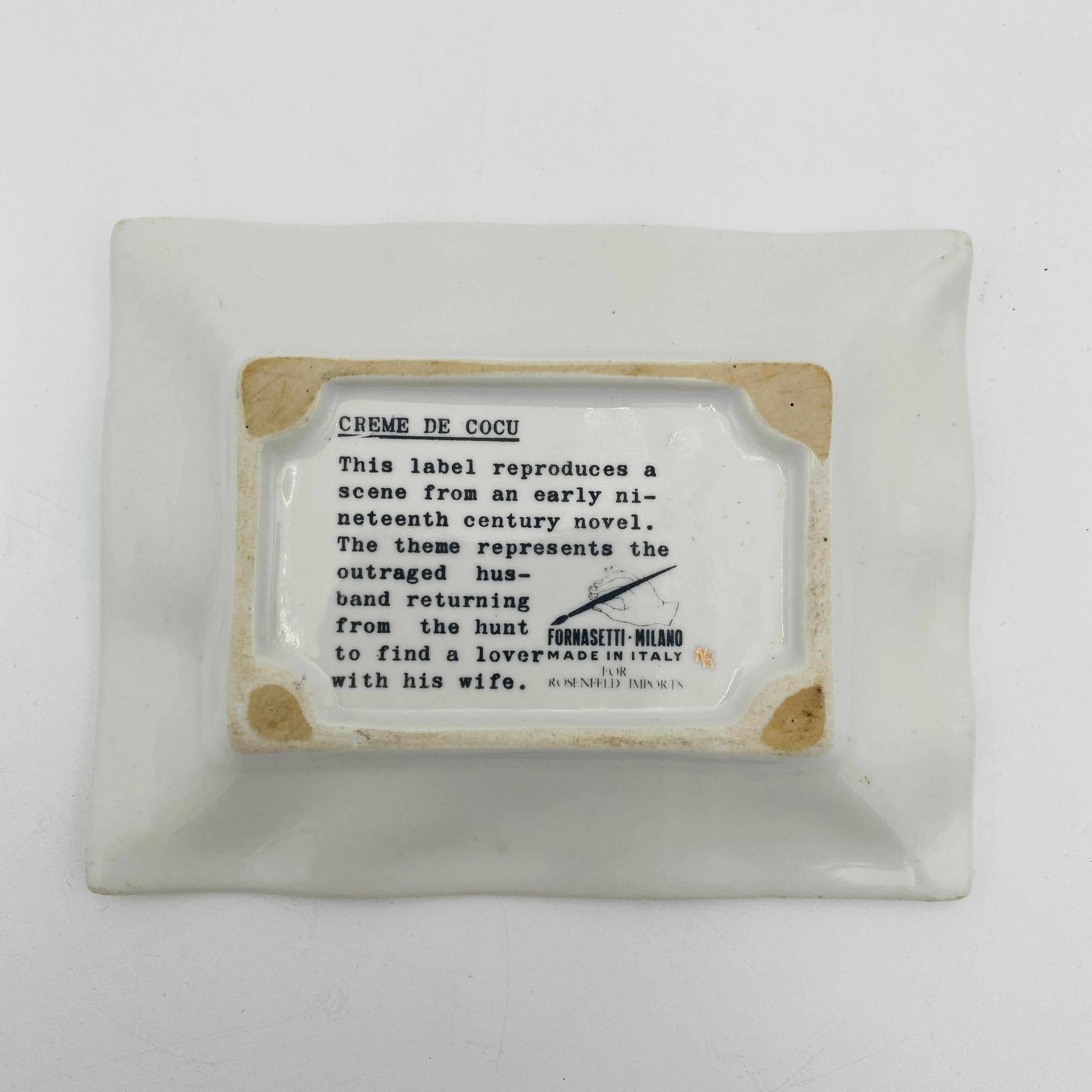 Ce superbe plat de Piero Fornasetti porte toute la signature du célèbre artiste italien : un graphique noir et blanc saisissant sur le devant d'une forme rectangulaire au bord ondulé chargé de dorures. Mesurant 5,5 pouces sur 4,25 pouces et d'une