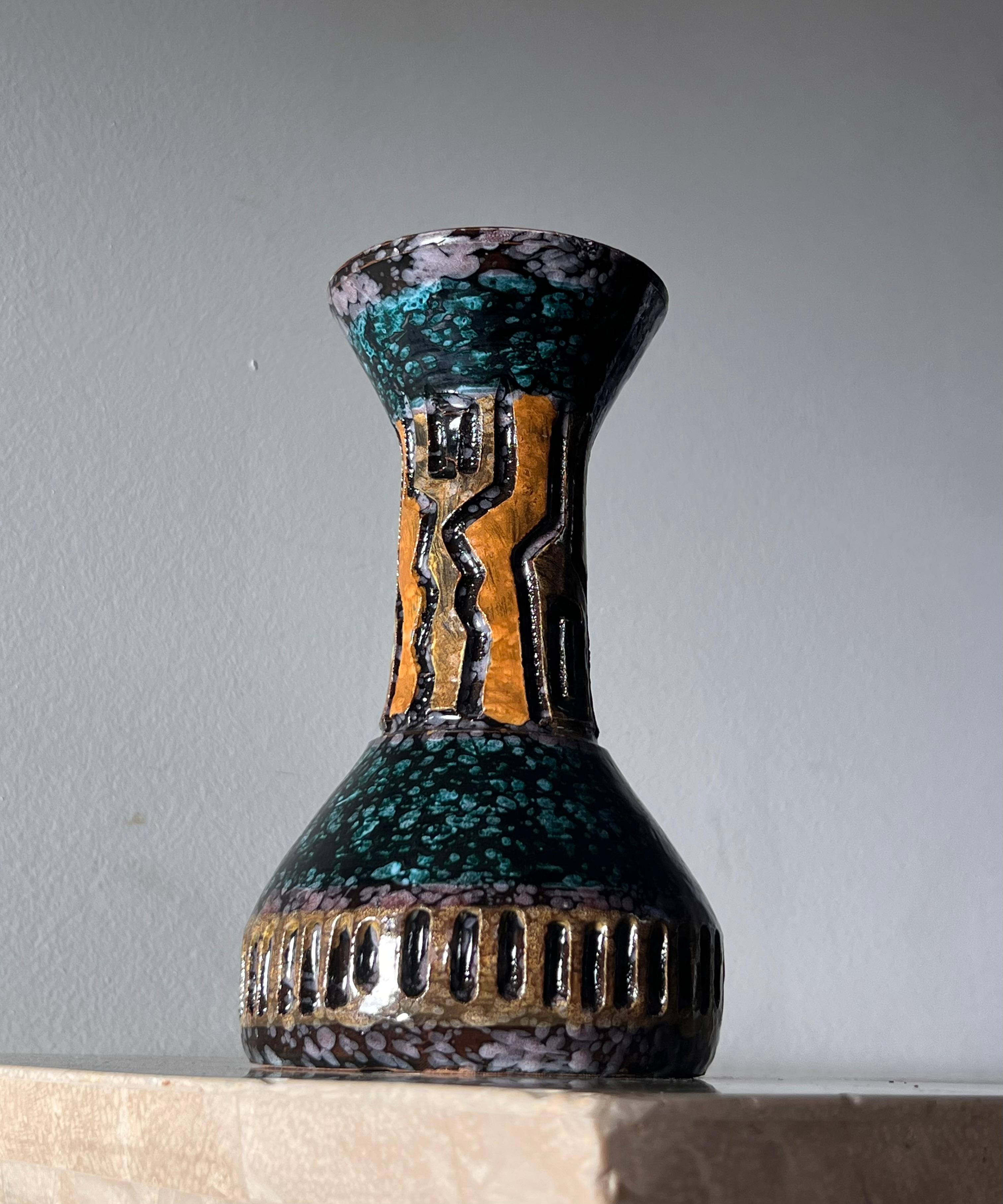A vintage Italian ceramic vase in the style of Guido Gambone, mid 20th century. Tones of violet, teal, and turmeric. 
4.3” diameter X 7.5” height 