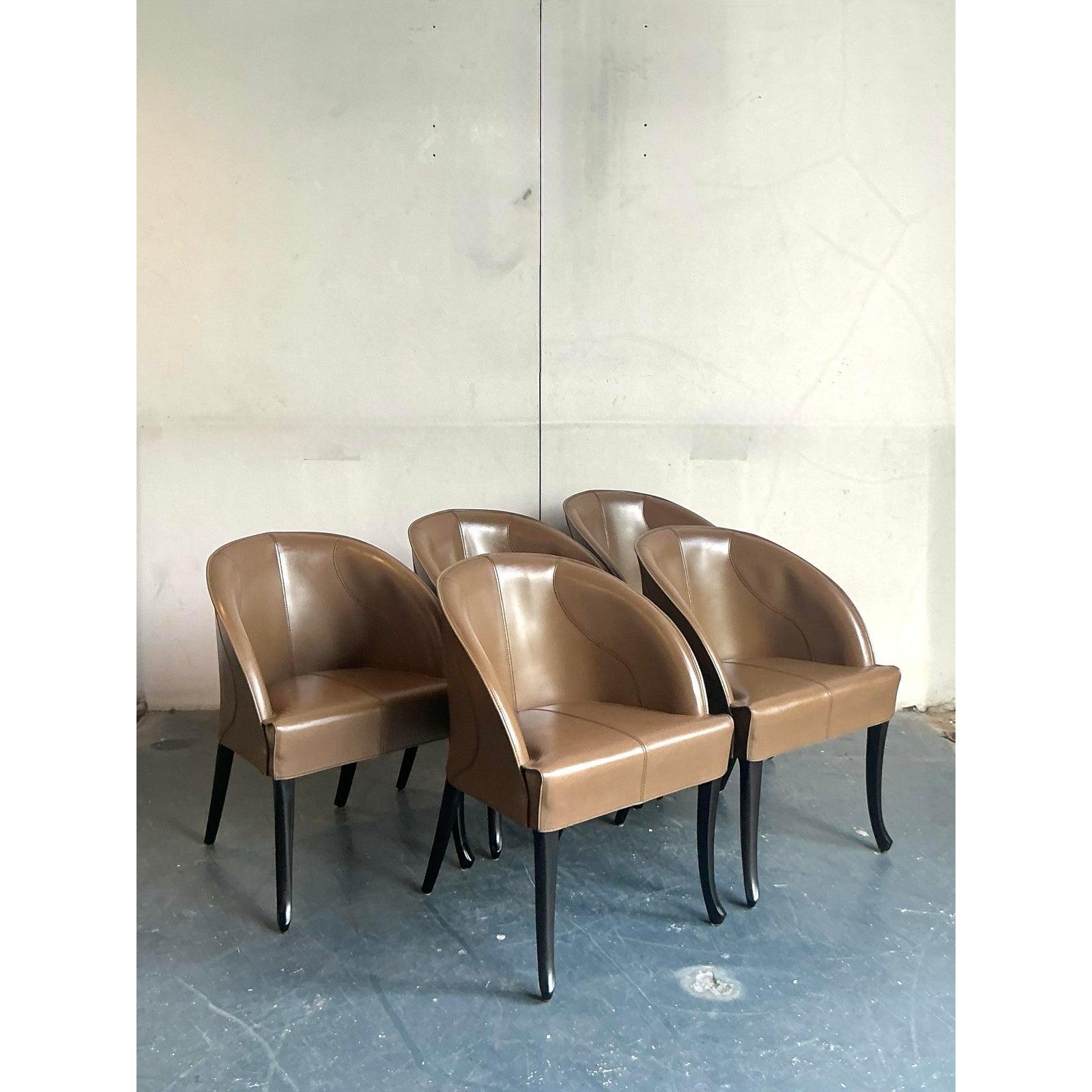 Define your dining experience with the sophisticated elegance of this exceptional set of five leather chairs by the renowned Italian maker, Giorgetti. Each chair features a gracefully enveloping barrel-back silhouette, expertly upholstered in a