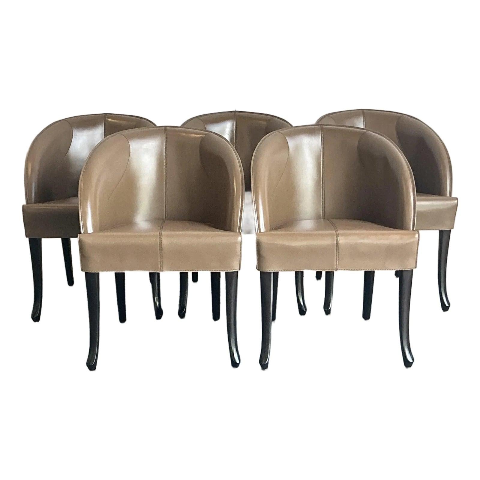 Eleganza sofisticata per questo eccezionale set di cinque sedie in pelle del rinomato produttore italiano Giorgetti. Ogni sedia presenta una silhouette graziosamente avvolgente con schienale a botte, sapientemente rivestita in una morbida e calda