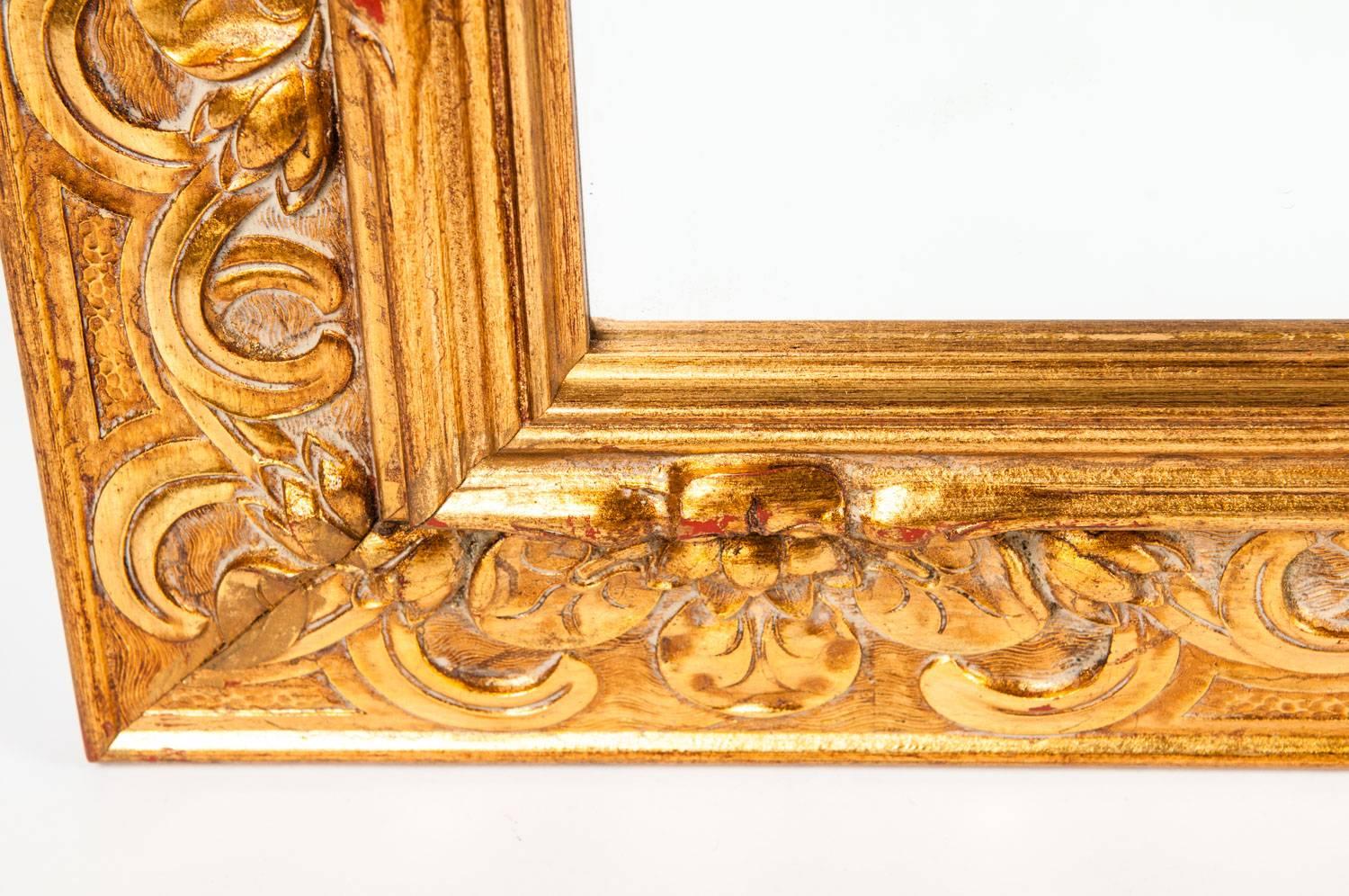 Large vintage Italian gilded wood framed hanging bevelled wall mirror. The mirror is in excellent vintage condition. The mirror measure about 58 inches length x 34 inches width.