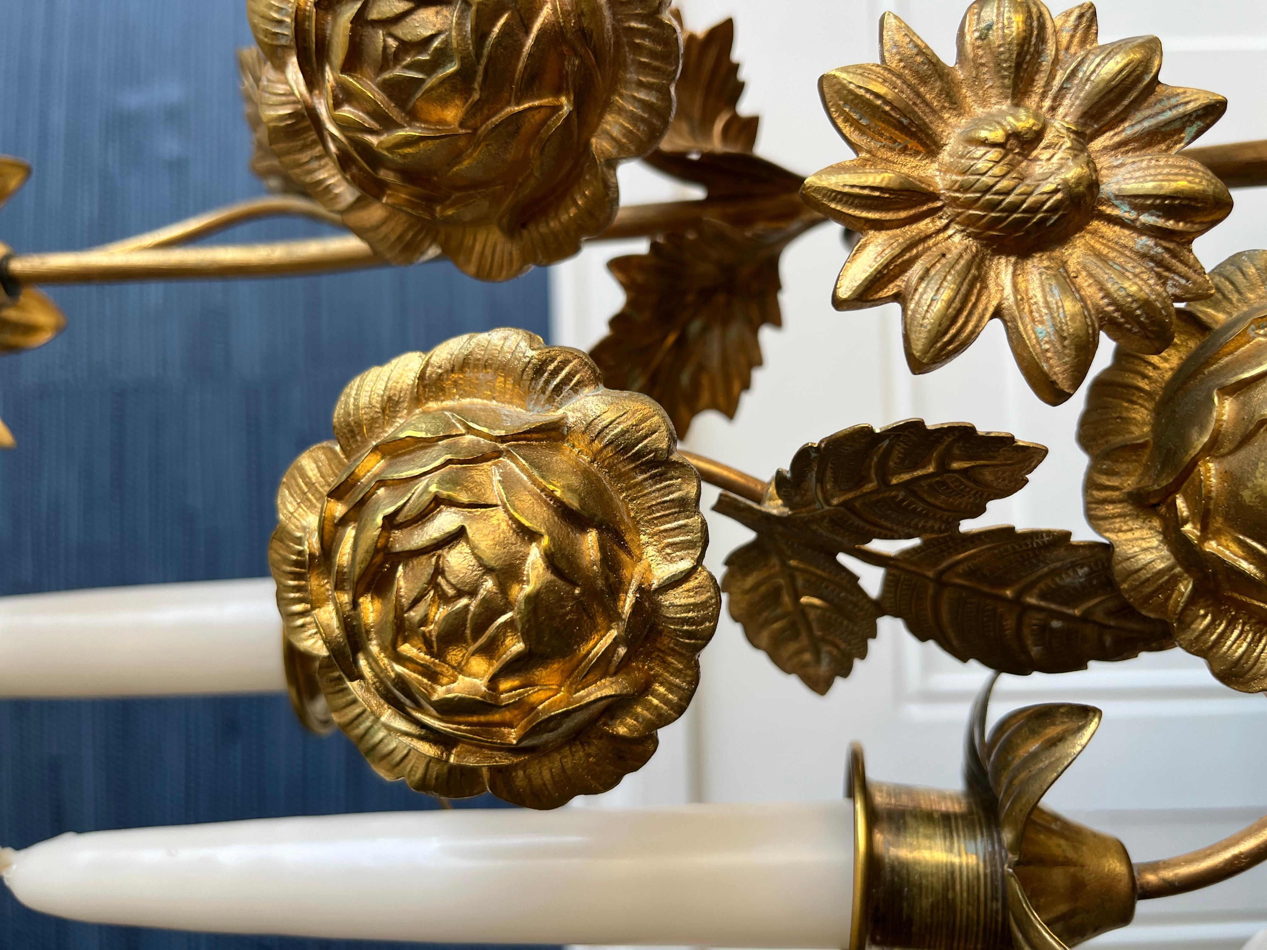 This 1940s Italian Florentine candelabra is a sculptural arrangement of gilded blooms, hand-formed in the traditional tole technique and finished in a warm, time-softened gold. With five candle arms and a bouquet of intricate flowers, it brings an