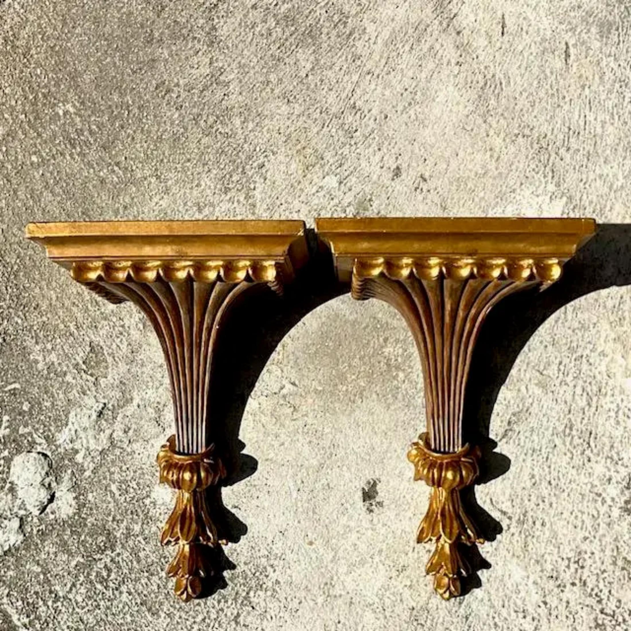 A fabulous pair of vintage Regency wall brackets. Chic gilt finish on a classic design. Acquired from a Palm Beach estate.
