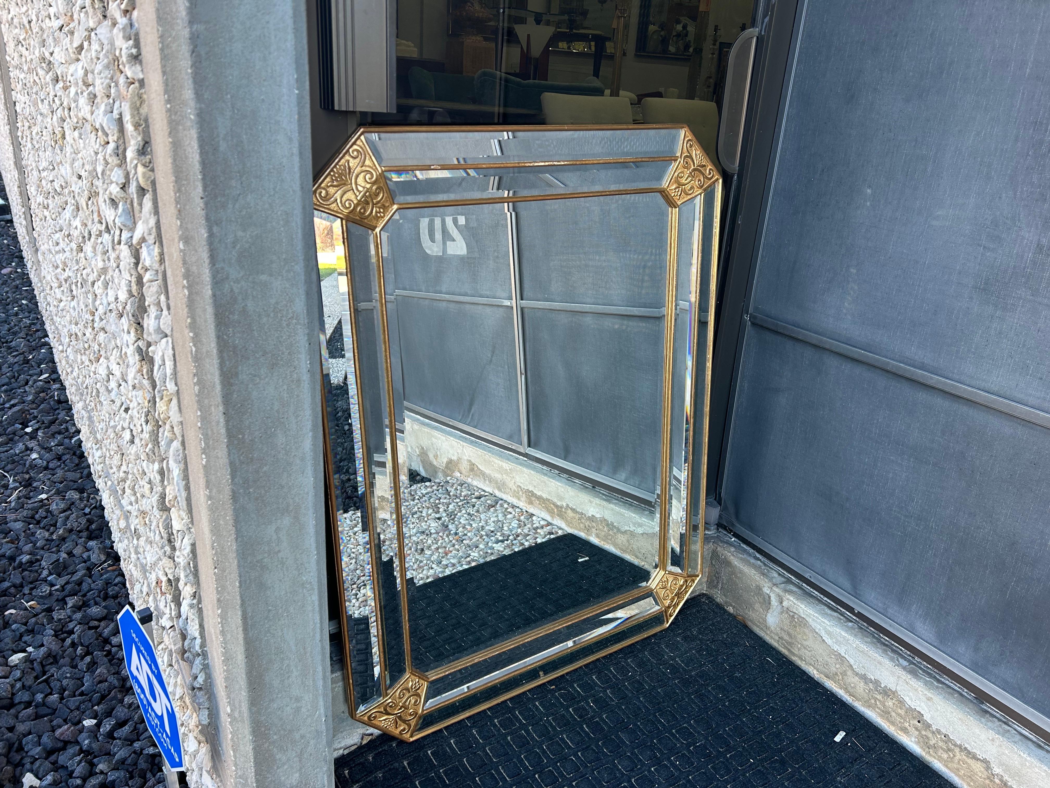 Specchio smussato in legno d'orato italiano d'epoca.
Questo splendido specchio italiano Hollywood Regency presenta bellissimi angoli decorativi in legno dorato e un perimetro smussato. Questo specchio italiano chic ha linee pulite ed è pieno di