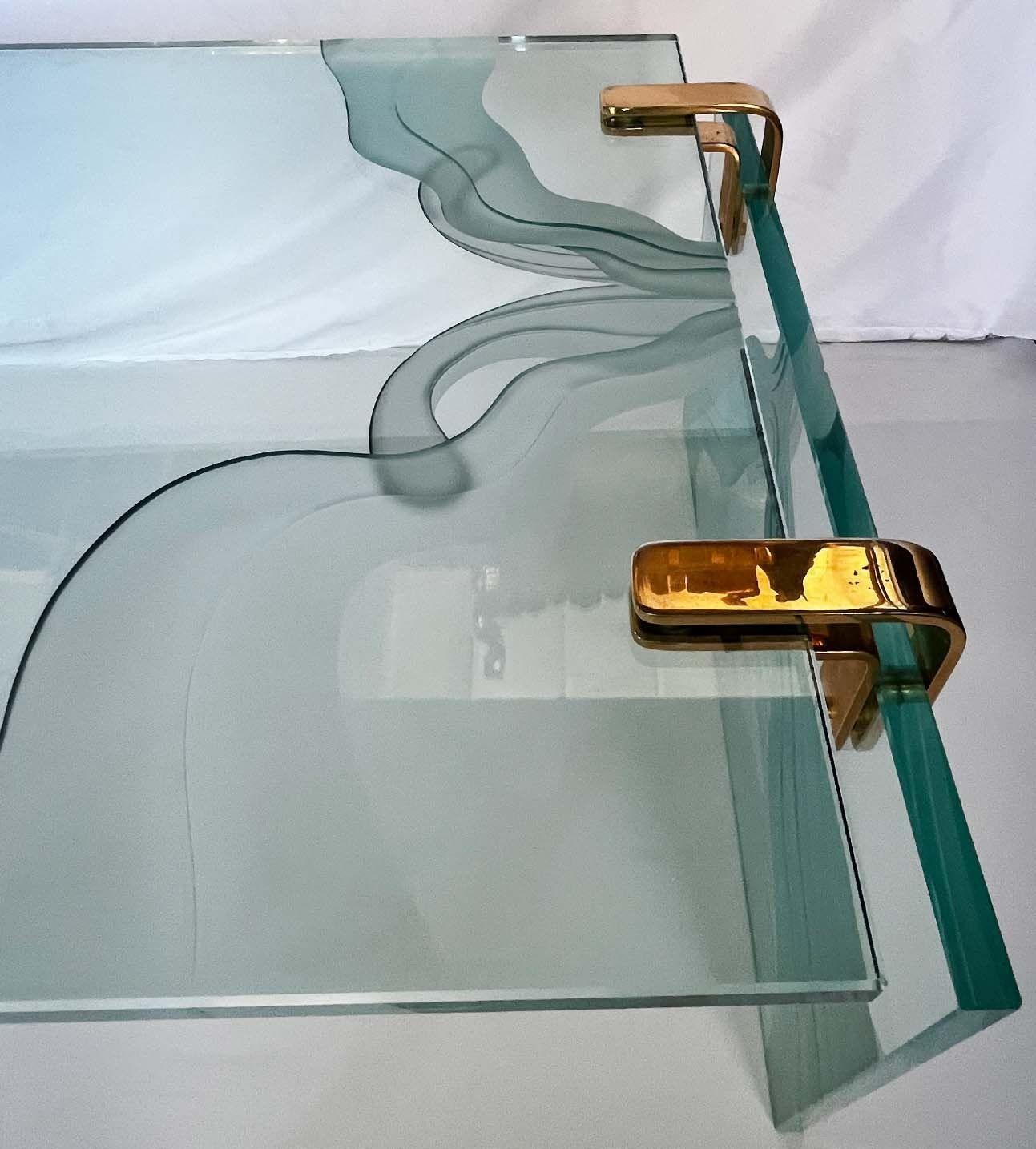 Graceful vintage coffee table in the style of Fontana Arte. Made with thick glass and wave-liked pattern frosted glass details around the piece held in place with brass hardware. 
Made in Italy, c. 1960's.
Dimensions:
17