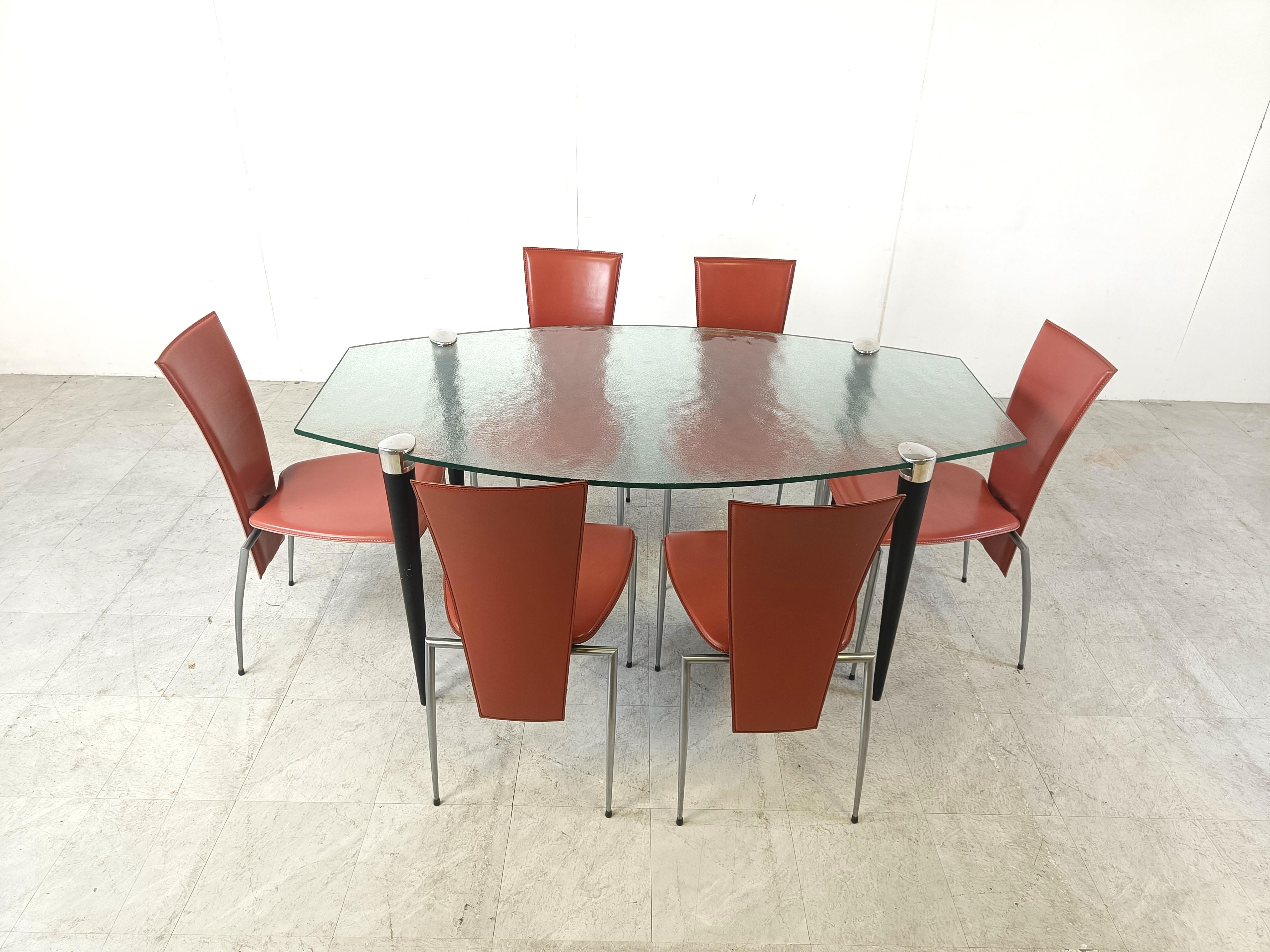 Table de salle à manger design italien des années 1990 composée d'un plateau en verre glacé de belle forme et de pieds coniques en bois et chromés.

Les pieds serrent le plateau de la table grâce à une seule vis sur chaque pied.

Design/One