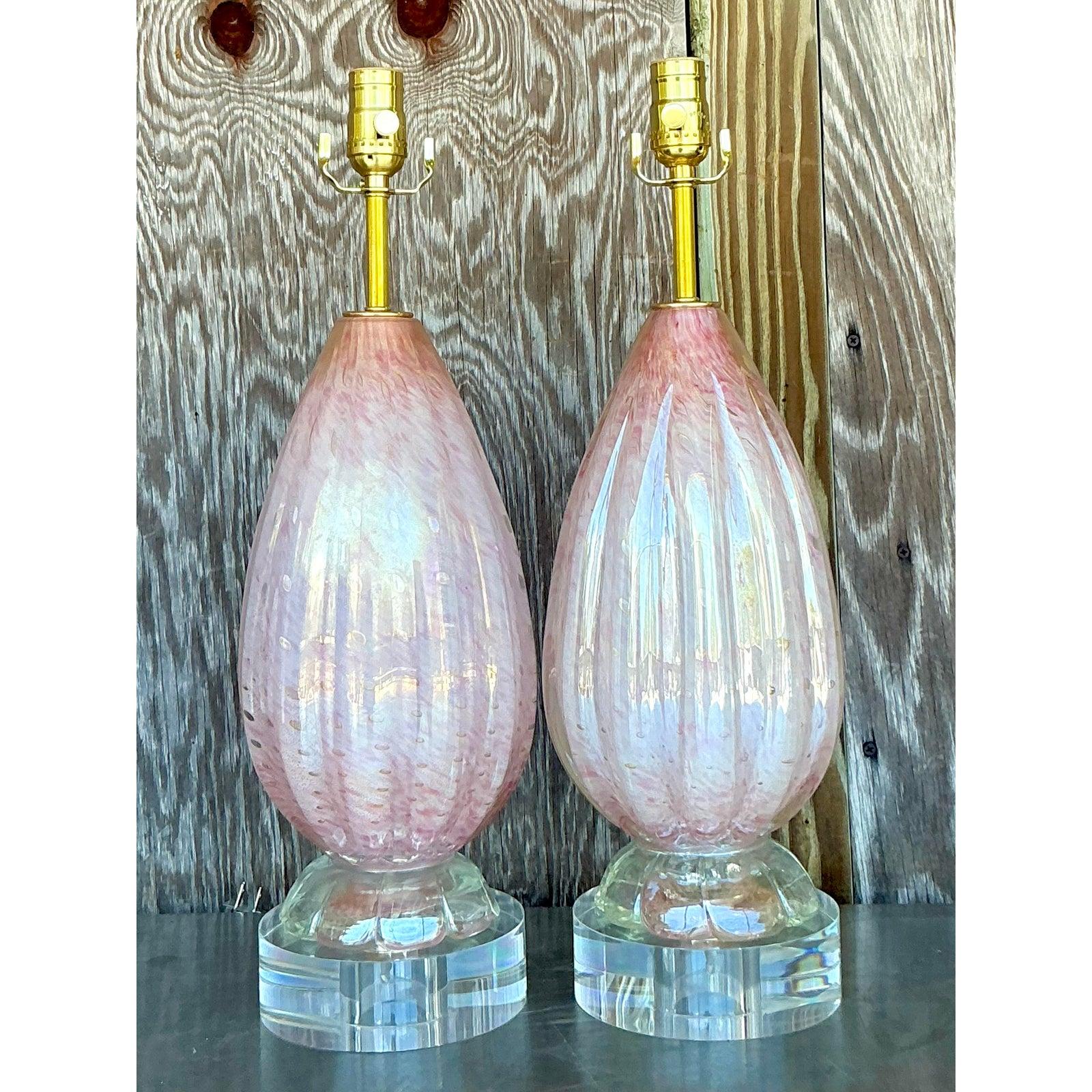 Capture the essence of 1970s glamour with this exquisite pair of vintage Italian glass table lamps after Murano. Each lamp is a testament to masterful Venetian craftsmanship, featuring a voluptuous, hand-blown glass body in a delicate rose pink hue
