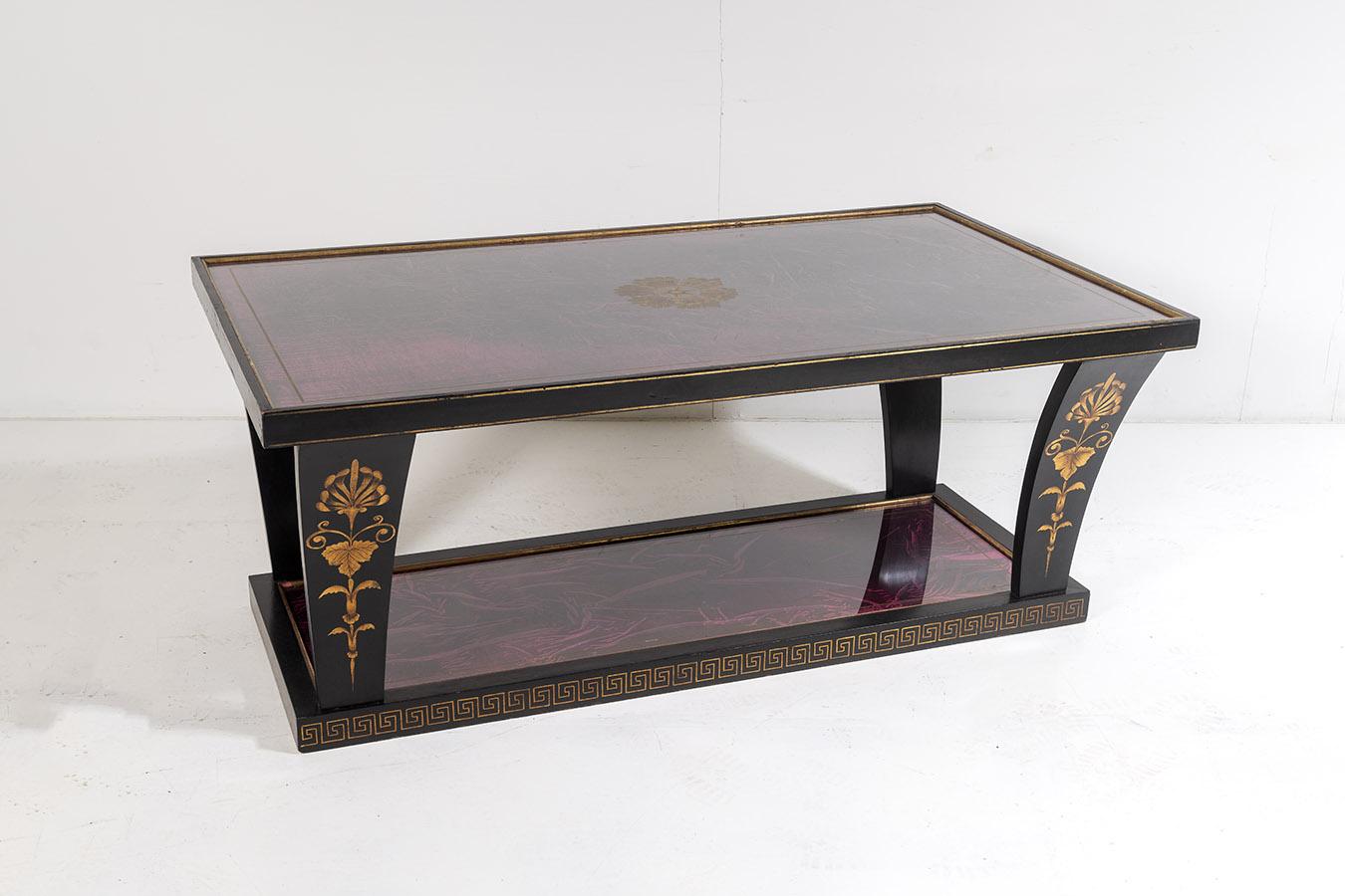 A stylish and highly decorative vintage Italian coffee table. An unusual design, rectangular with four curved legs leading to a bottom glass shelf.
Ebonised finish with gold gilt detailing, floral motifs and Greek key pattern to the base. Top and