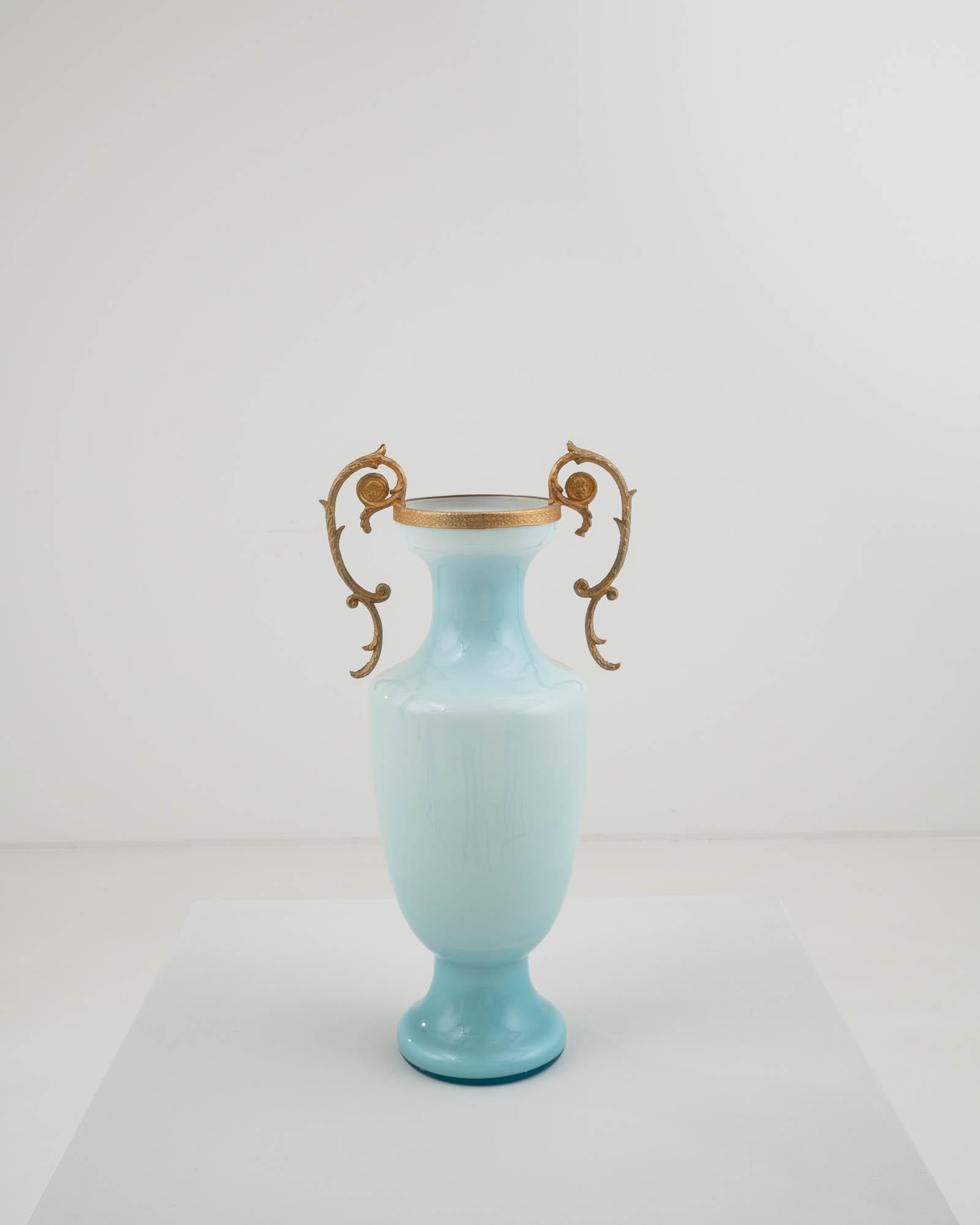 Handcrafted in Italy in the 20th century, this vintage vase showcases a unique tone of glass, smoothly transitioning from light, almost white hues to a deep pastel blue. This gradient accentuates its refined silhouette and interplays beautifully