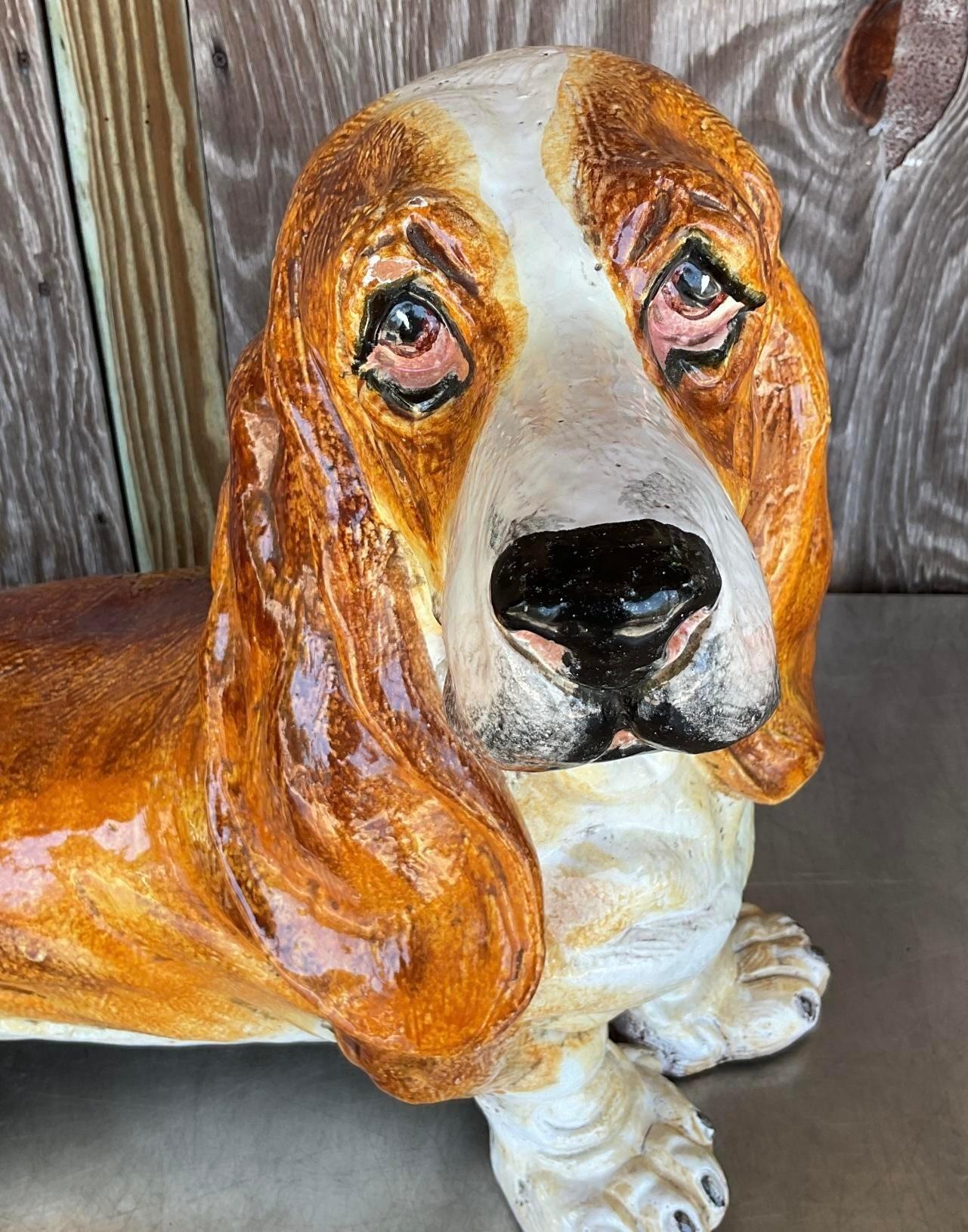 Elevate your home decor with this vintage Italian glazed ceramic Basset Hound. With its charming presence and timeless appeal, this piece adds a touch of Americana whimsy to any space, celebrating the beloved breed in classic style. 