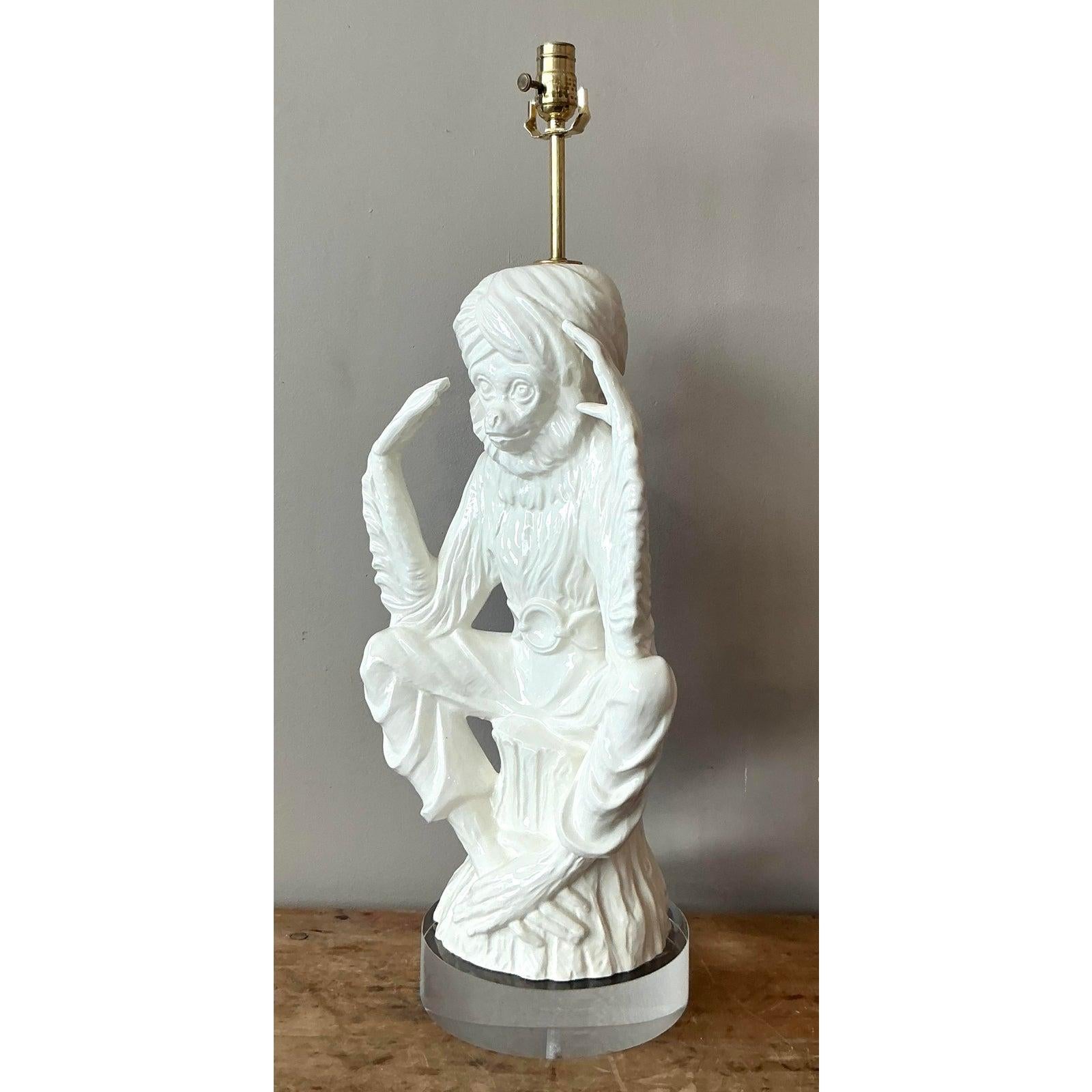 Cette lampe de table spectaculaire est un exemple typique du maximalisme Hollywood Regency, illustrant un design ludique mais très sophistiqué, populaire dans les années 1970. Le luminaire présente une grande figure en céramique blanche brillante