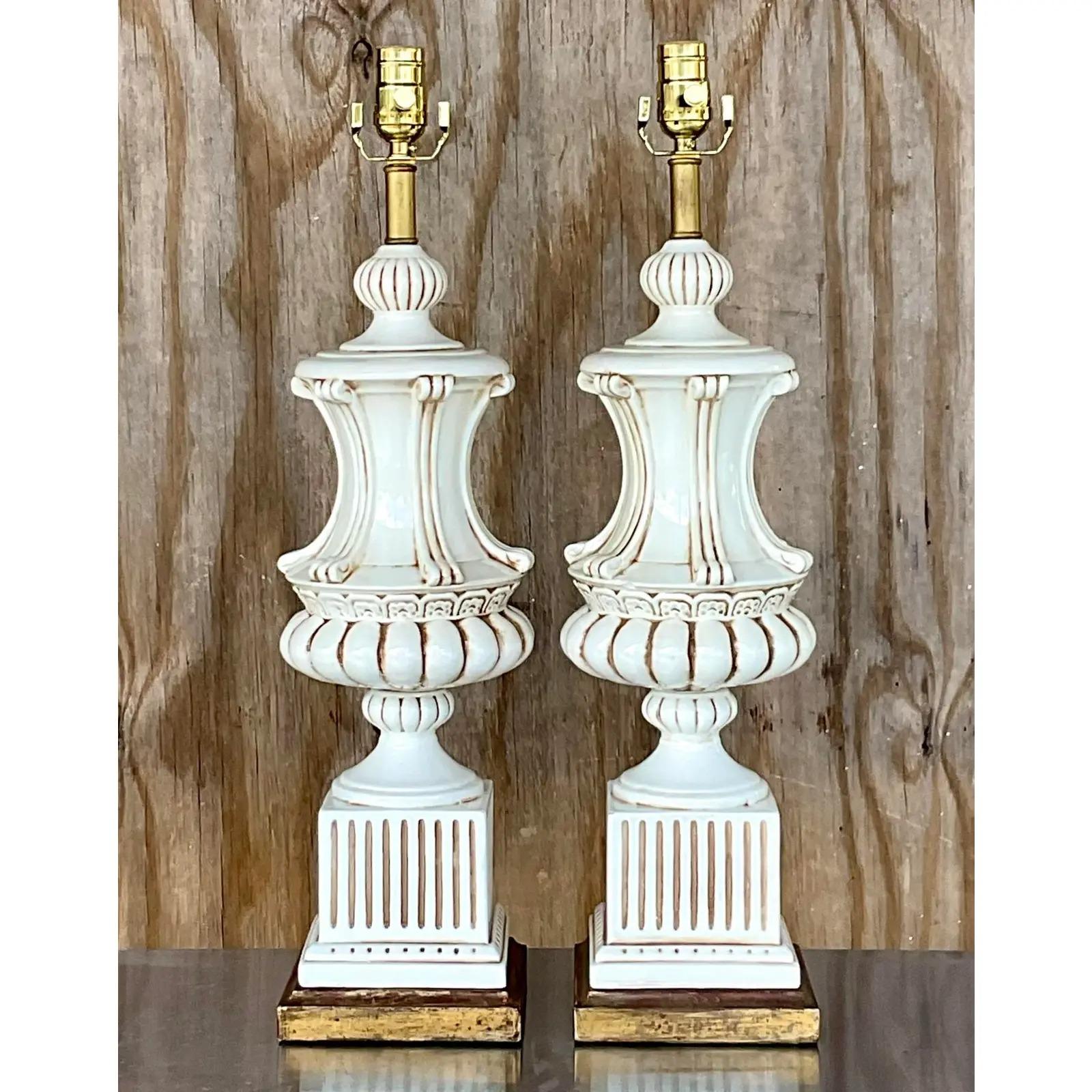 A fantastic pair of glazed ceramic table lamps. Made in Italy. Beautiful classic urn shape that rests on a gilt wood plinth. Fully restored with all new wiring and hardware. Acquired from a Palm Beach estate.